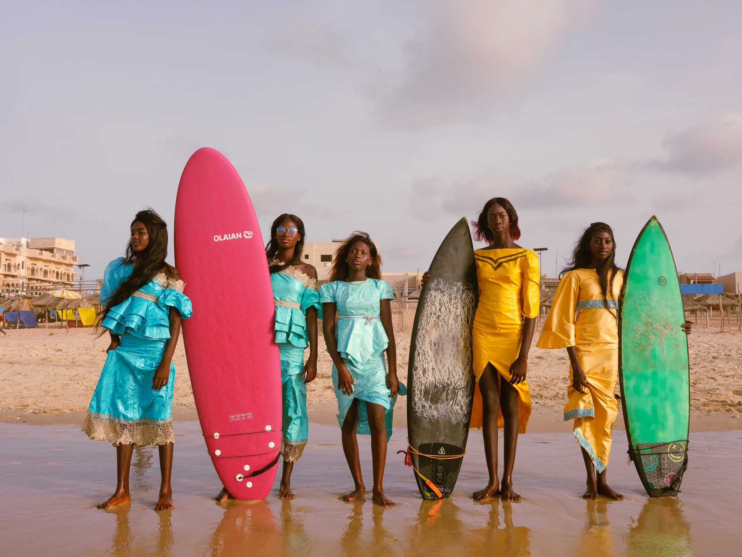 Group of colleagues holding surfboards on a beach