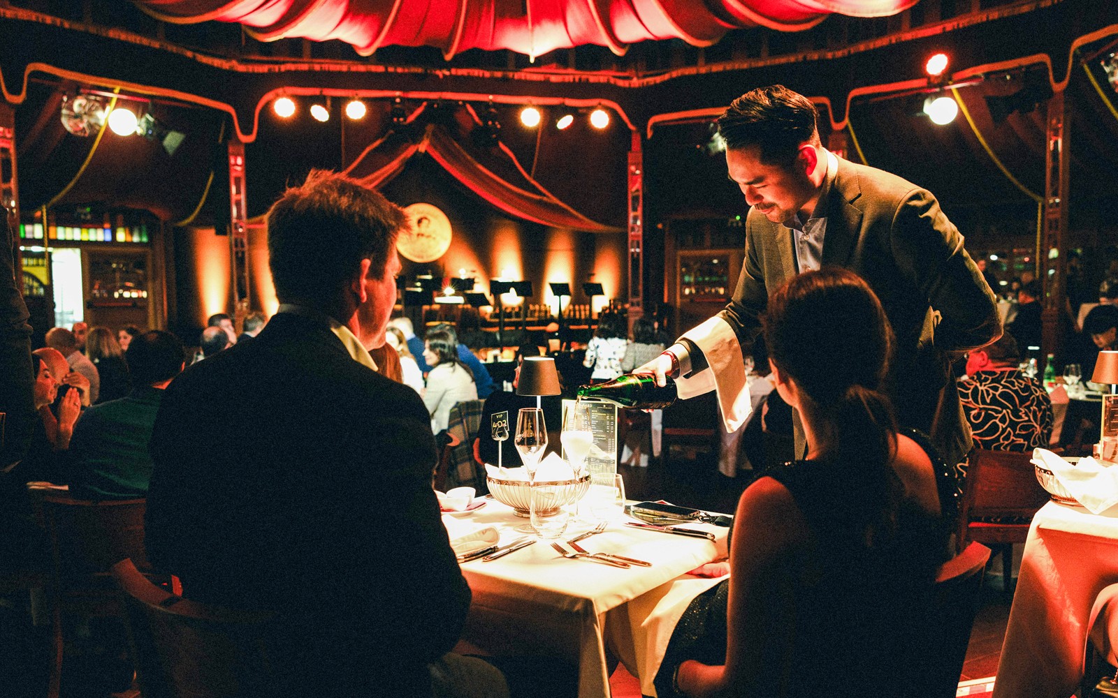 在维也纳普拉特的施特劳斯音乐会期间，服务员在烛光晚餐时倒酒。