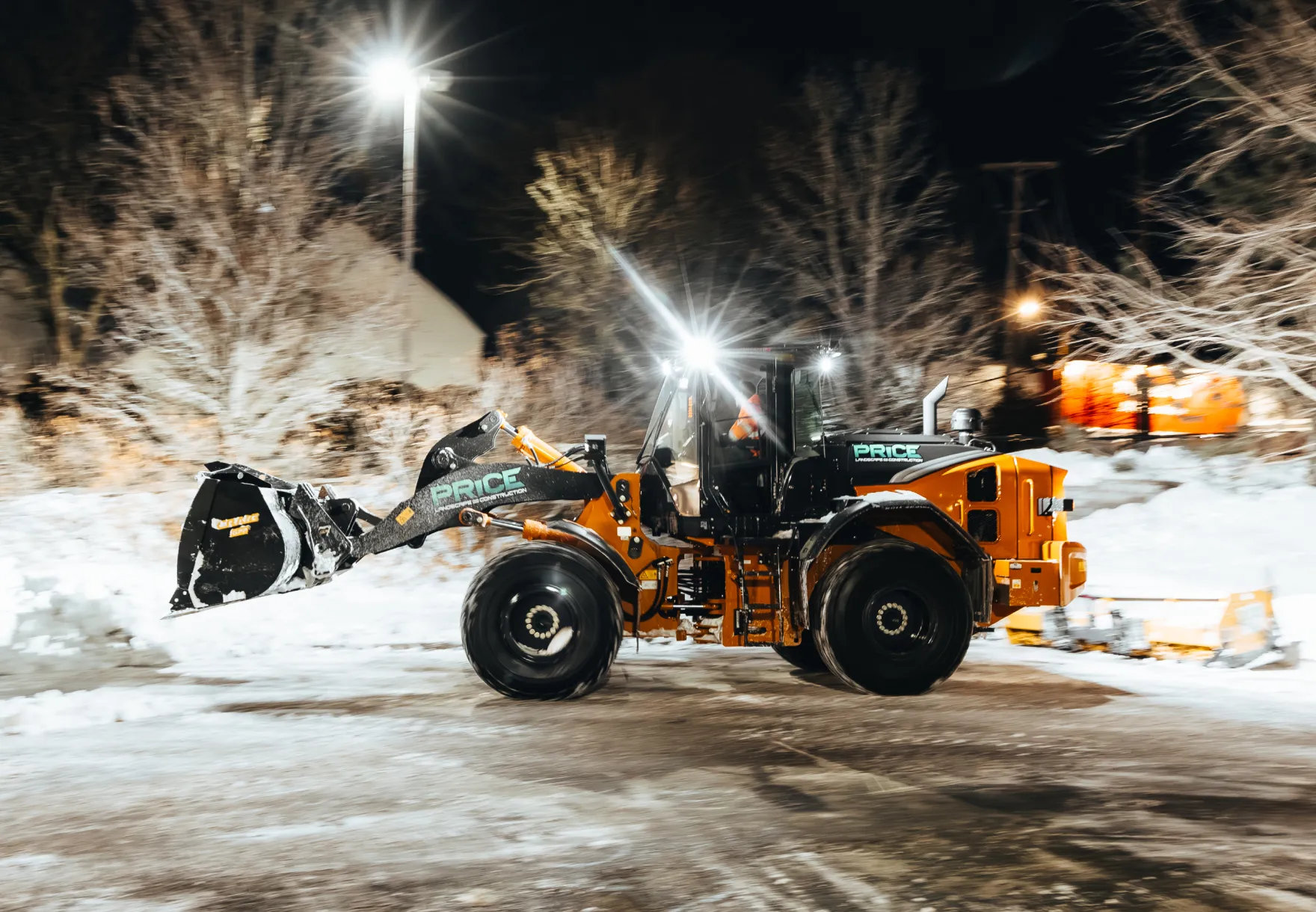 Price Landscape and Construction onsite at a business parking lot with a loader doing snow removal