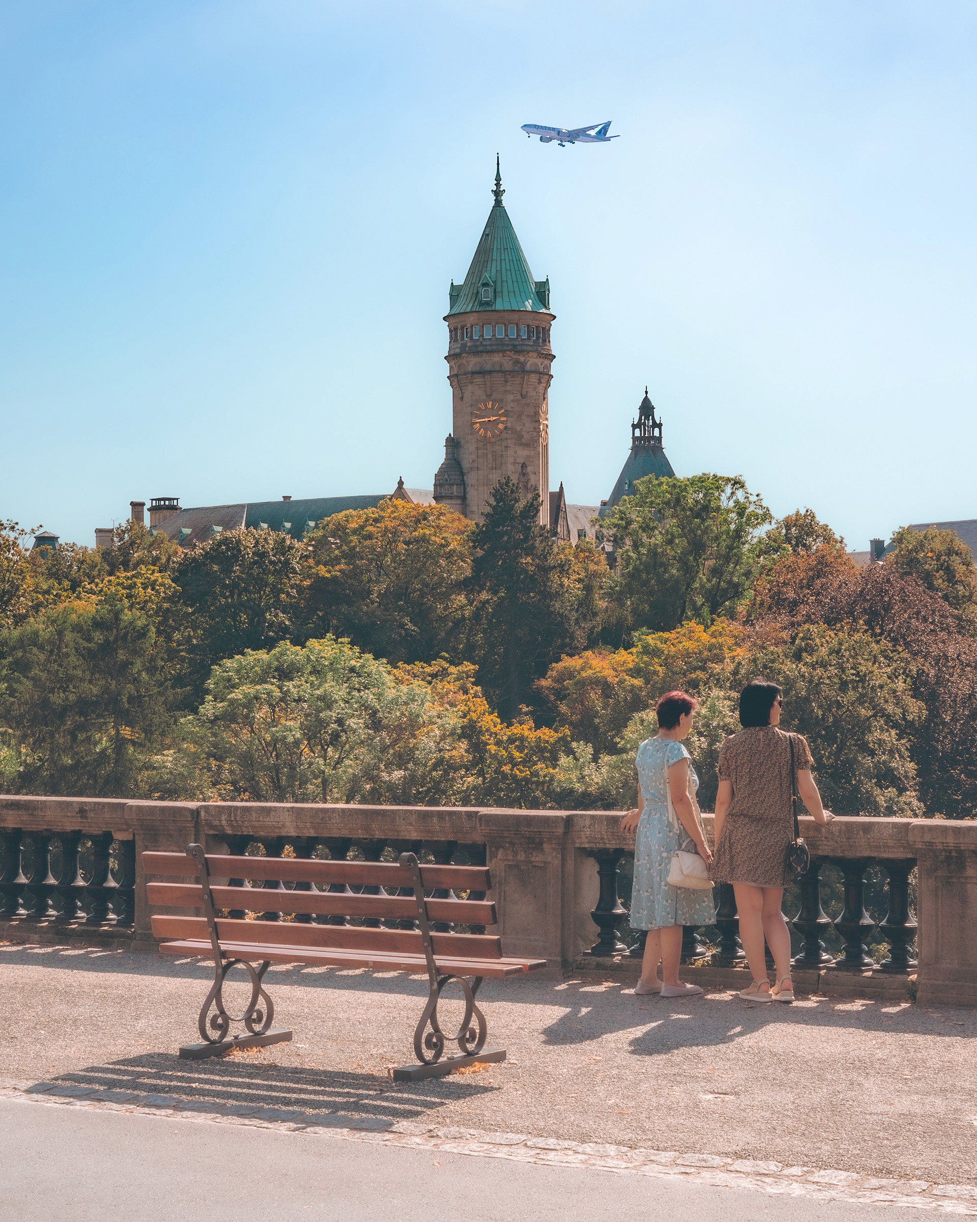 woman in blue tank top standing beside white wall