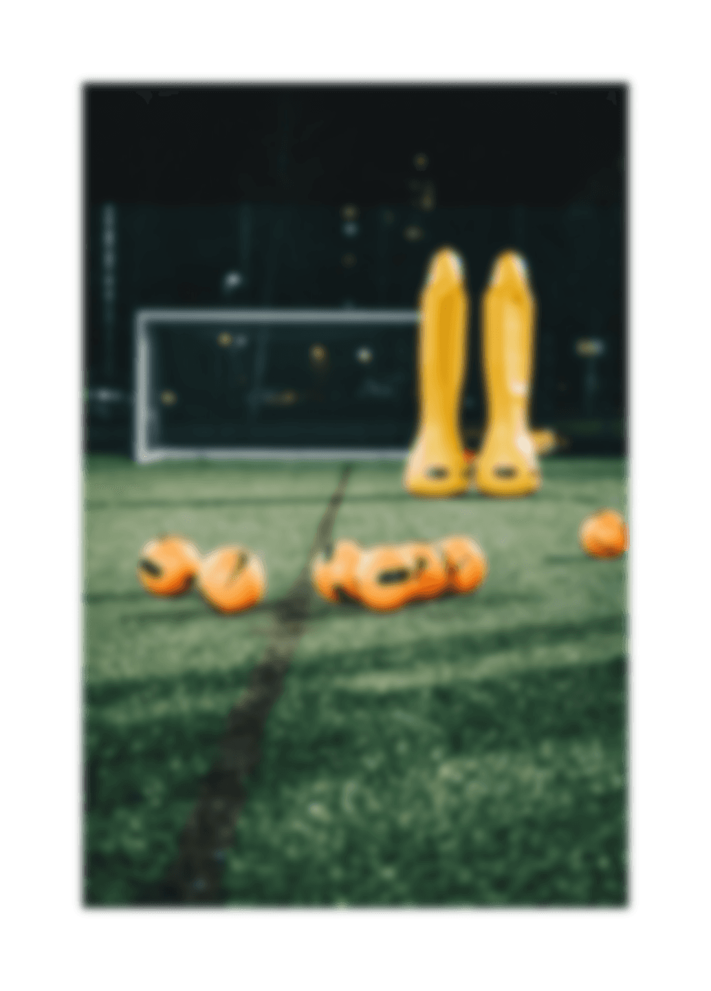 a group of yellow and orange balls on a green field
