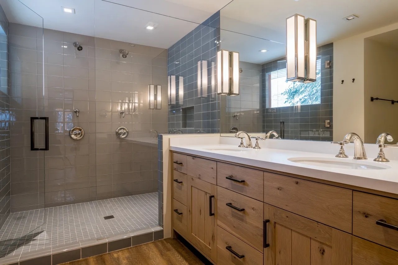 Bathroom with a double oak vanity and a gray-tiled walk-in shower