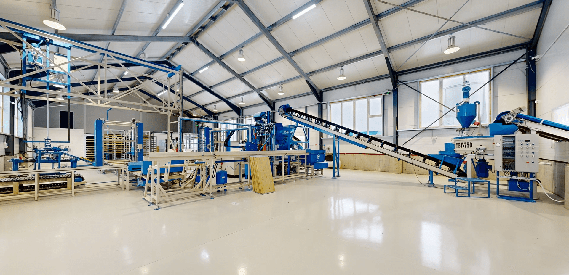Minimalist living space with low modern furniture, large floor-to-ceiling windows, soft natural light, and an open view of a calm outdoor landscape.