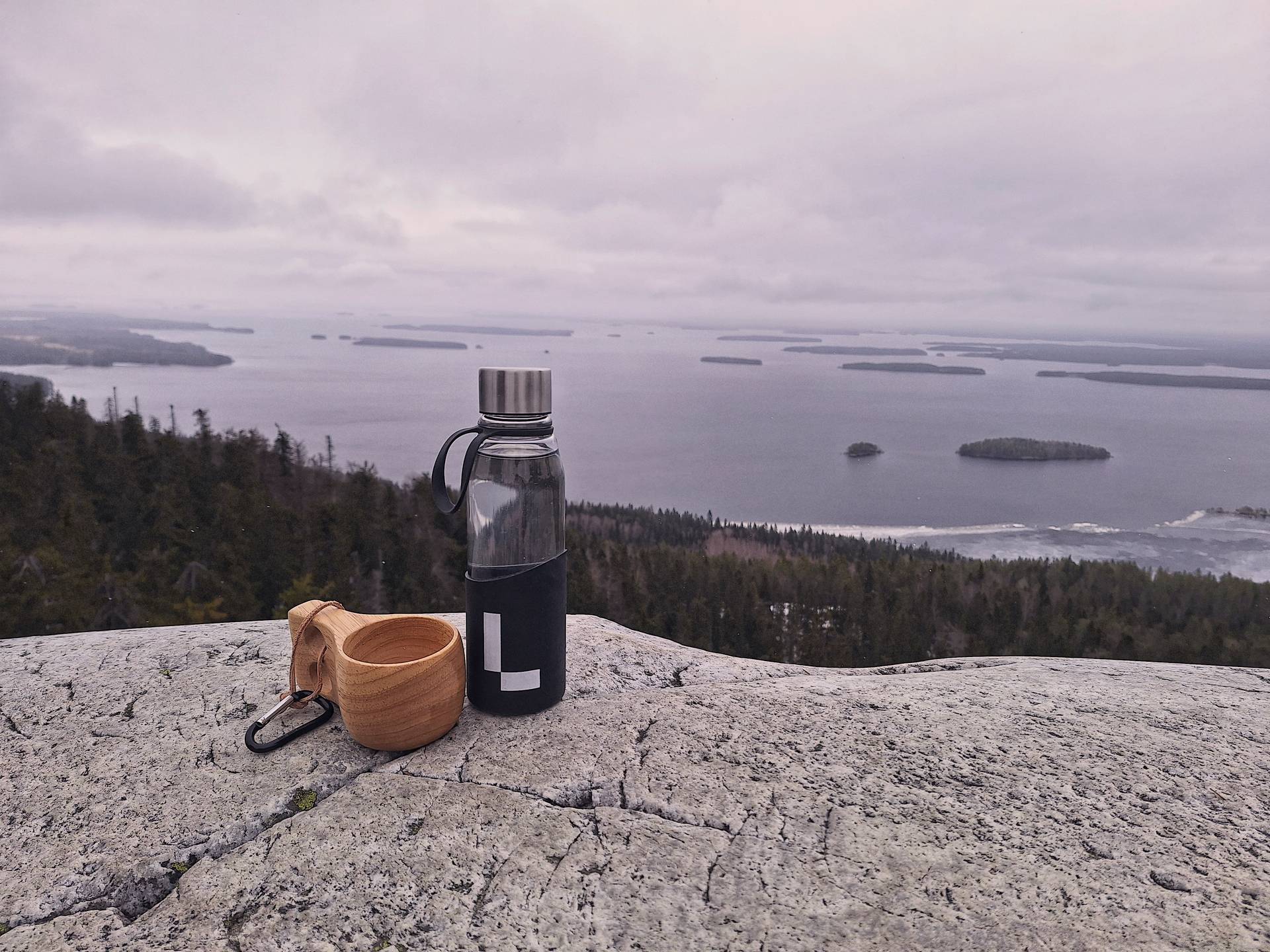  A glass building reflects a blue sky and trees with orange and yellow leaves.