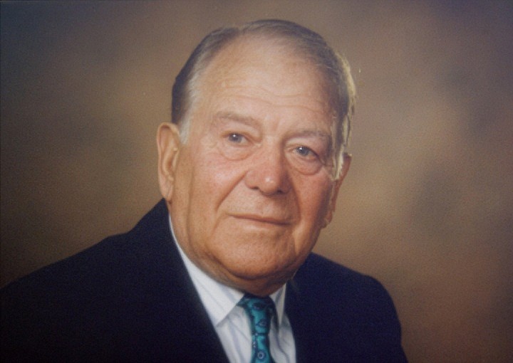 Professional portrait photograph of Alan Lenton in dark suit and patterned tie
