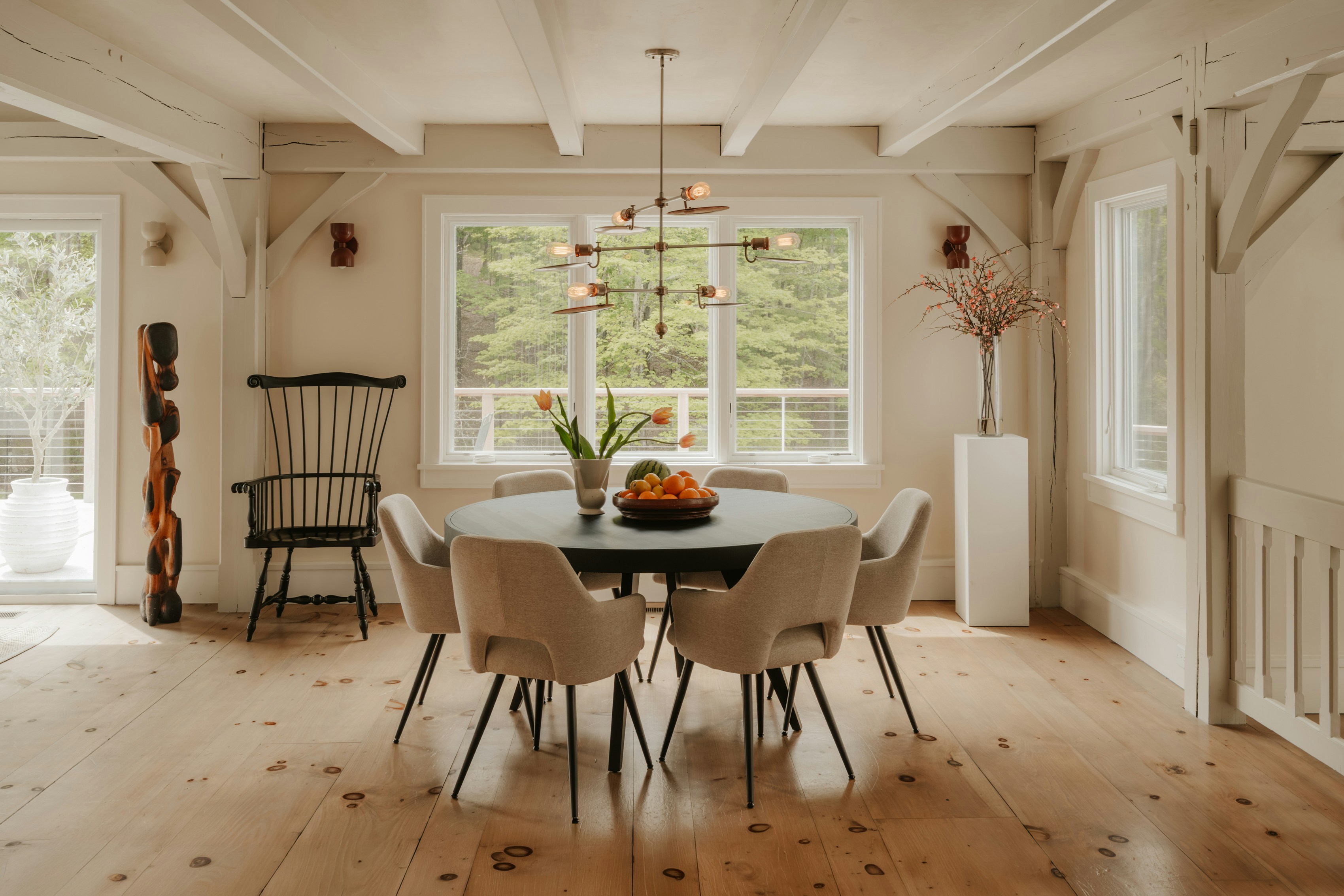 Modern dining room with a round table and large windows.