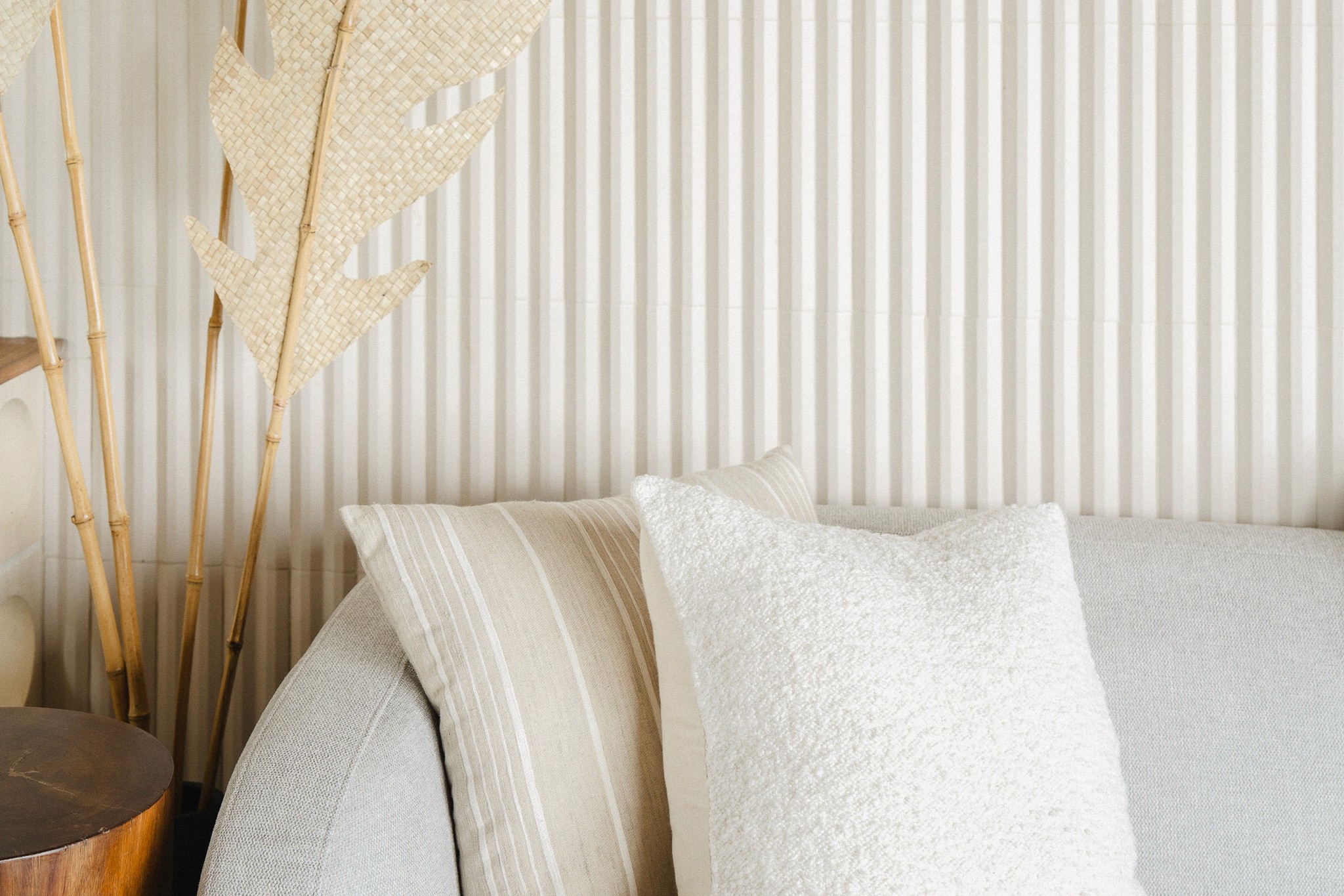 nfinity pool blending into the ocean view, minimalist sun loungers in soft neutral fabric, curved architecture