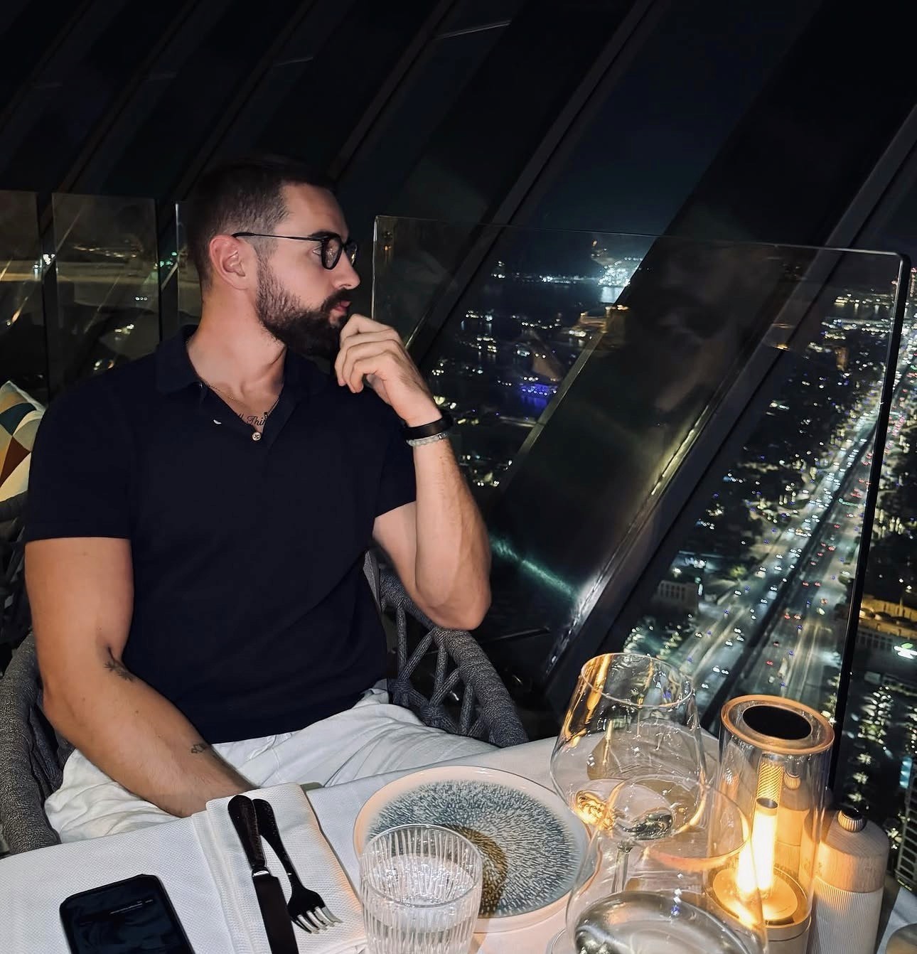 Professional headshot of a business advisor in a white shirt, smiling confidently against a warm neutral background.
