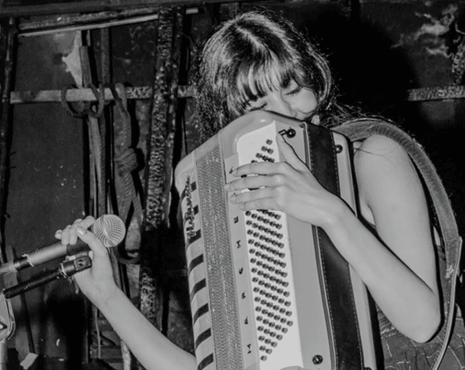 A man playing a drum in front of a group of people