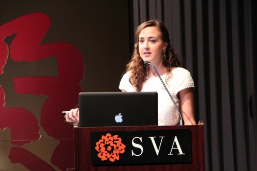 a woman giving a speech from a stand in the "designer as" thesis presentation