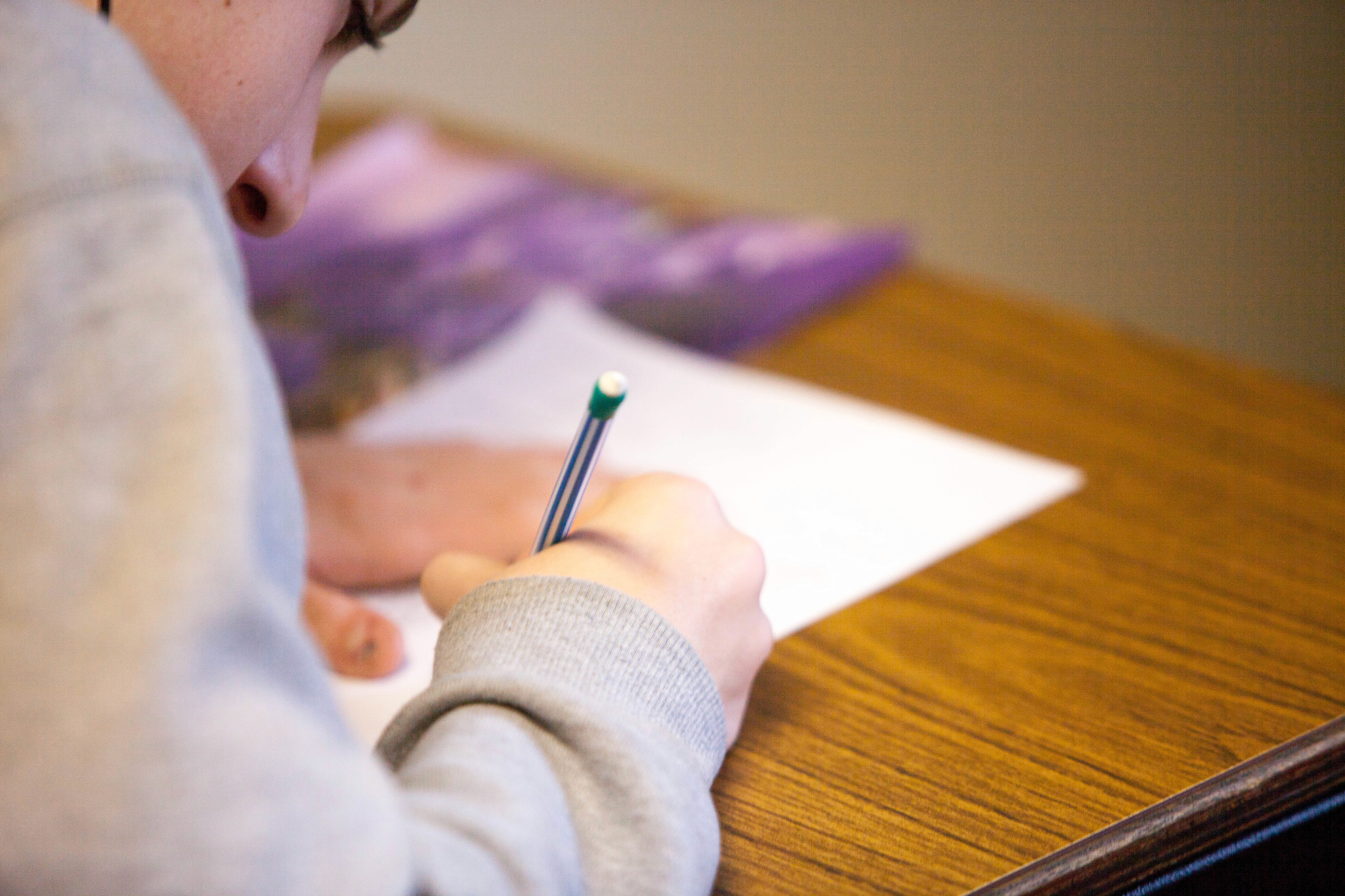 Student writing with pencil