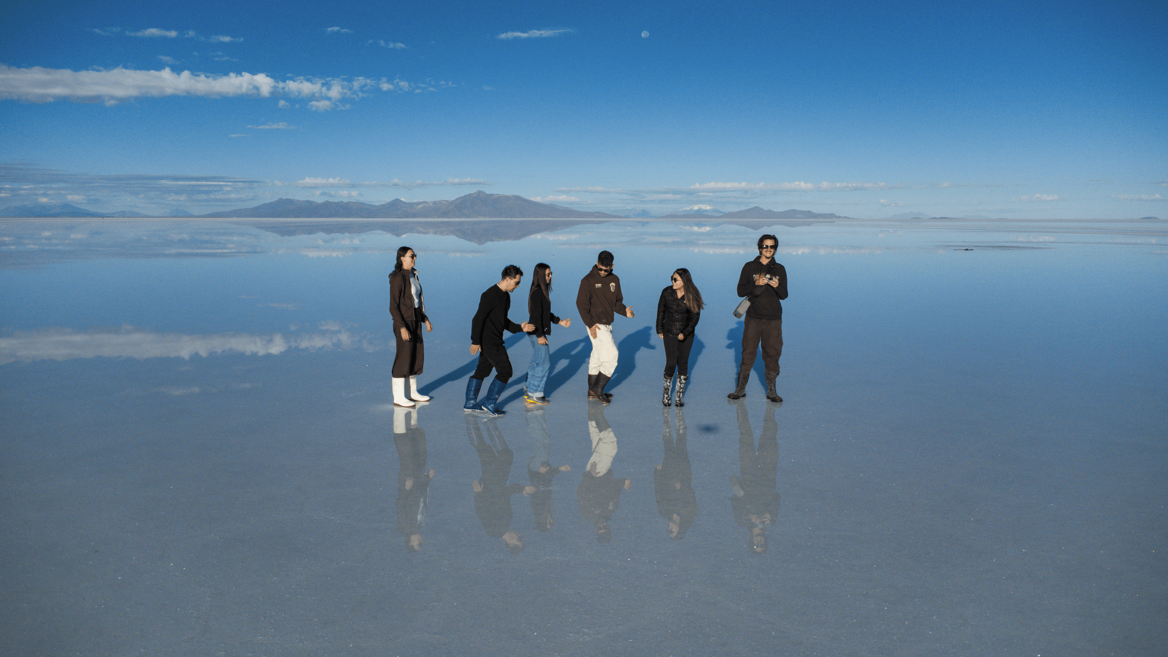 man standing near cliff looking at body of water during daytime