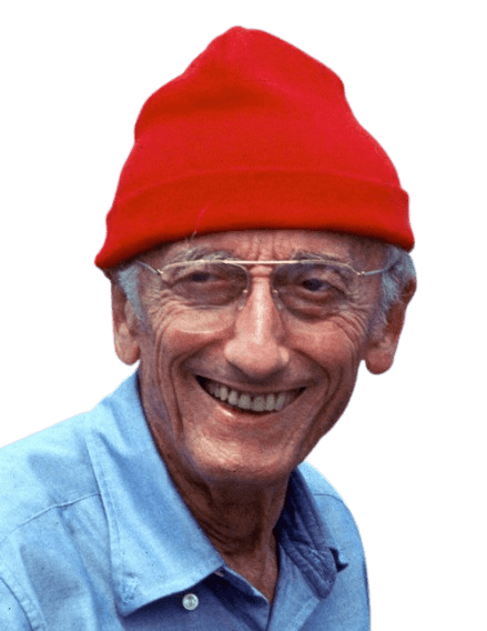 A vibrant portrait of an elderly man wearing a red beanie, glasses, and a light blue shirt, smiling warmly with the ocean in the background. His casual attire and cheerful expression evoke a spirit of adventure and a deep connection to marine life.