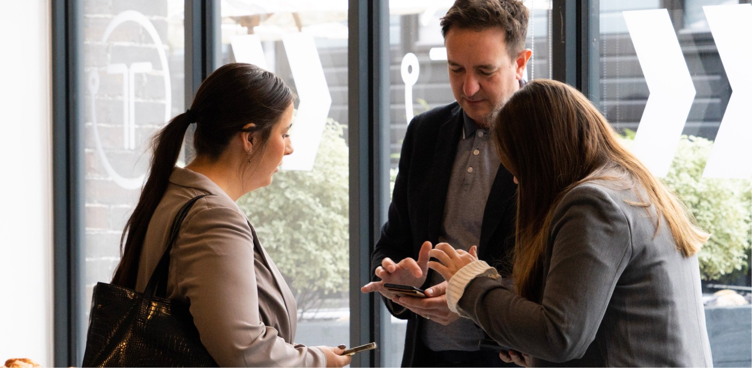 People talking and looking at a phone.