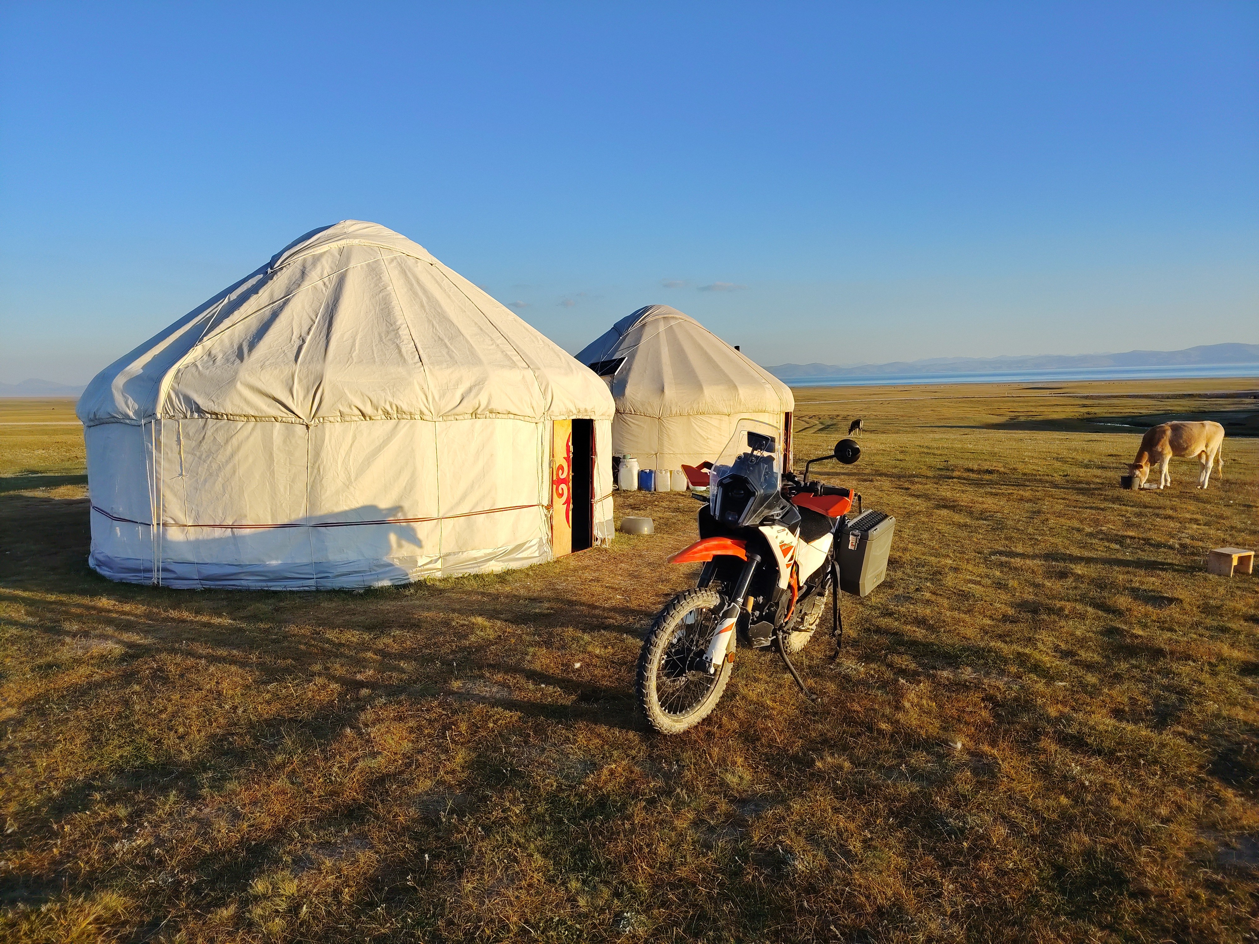 Ray's motorcycle beside yurts during his journey across Central Asia.