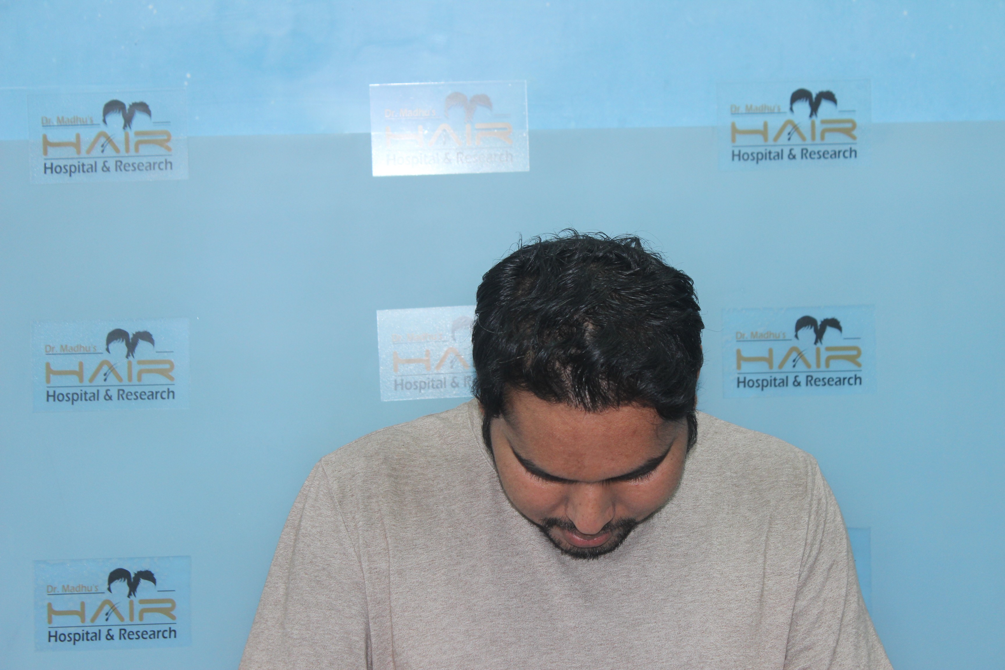 Smiling person in straw hat with orange ribbon and blouse against plain light background