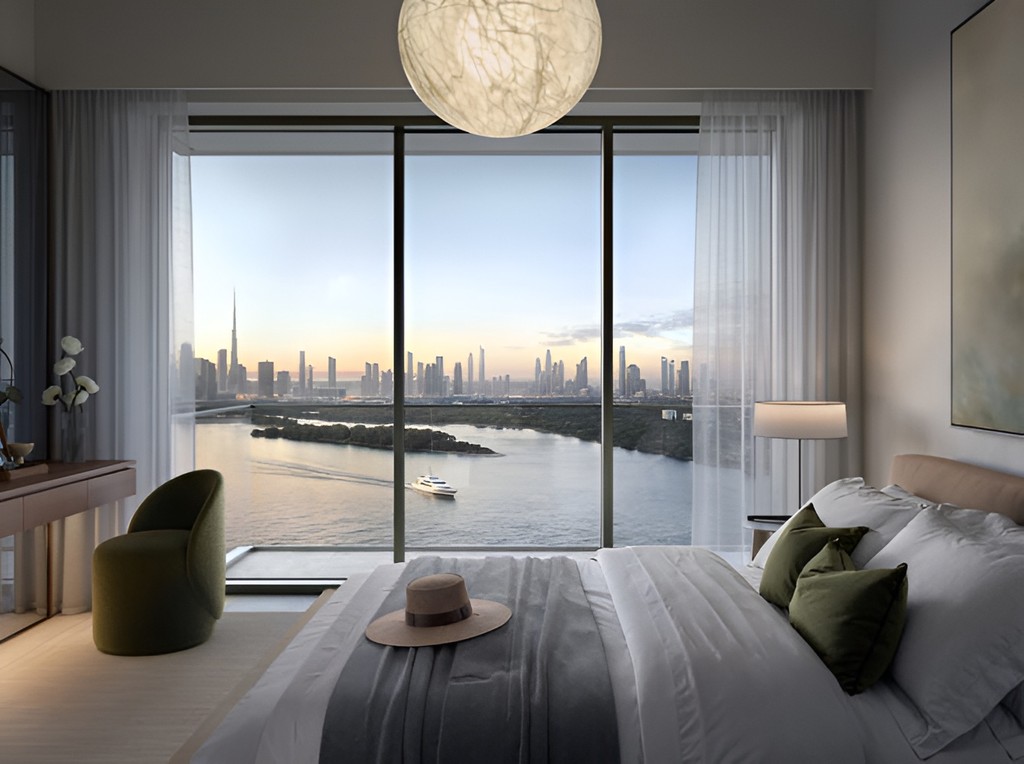 Modern bedroom with large windows showcasing a scenic view of the city and waterfront at Creek Bay Emaar Properties.