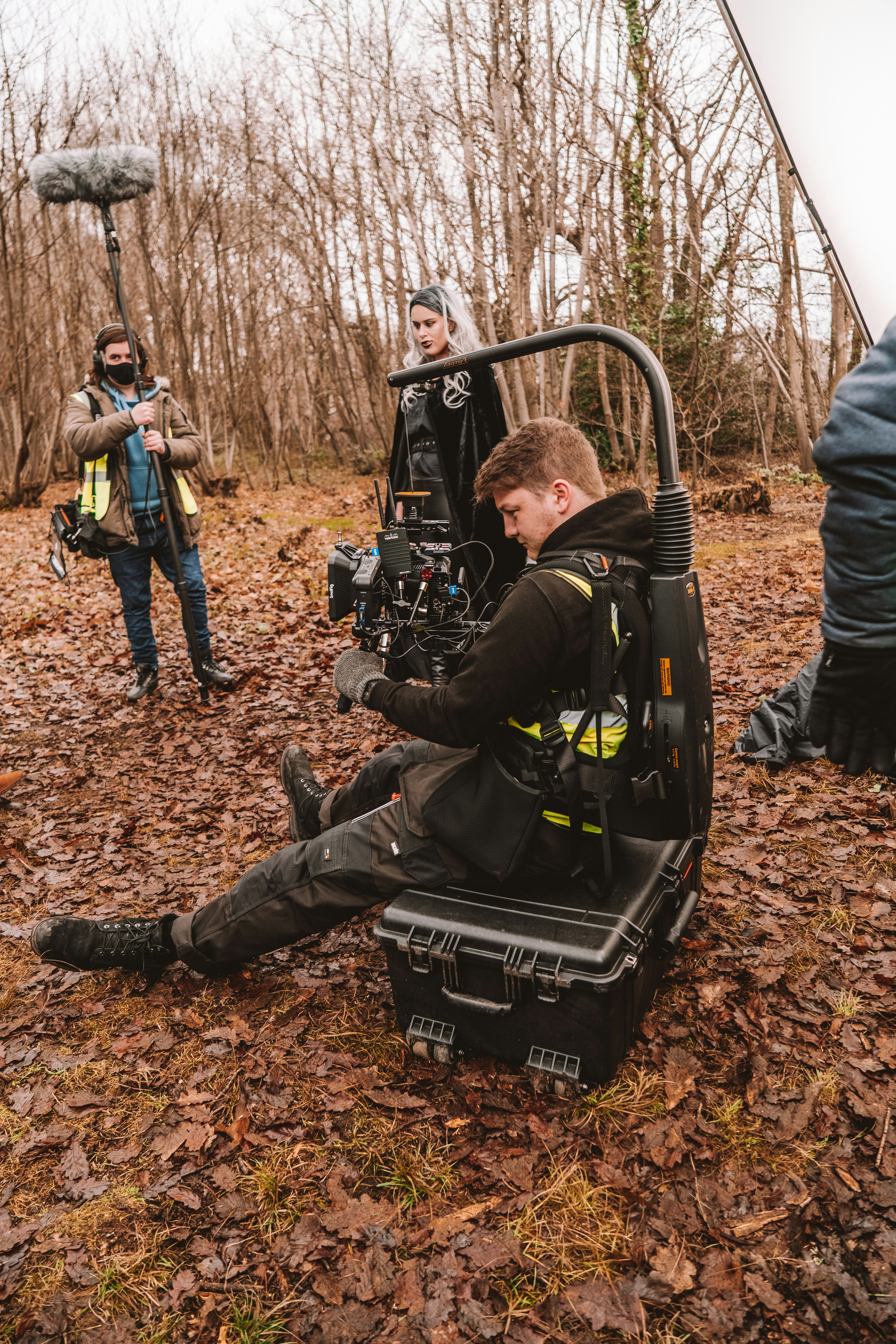 a man sitting on the ground in front of a camera