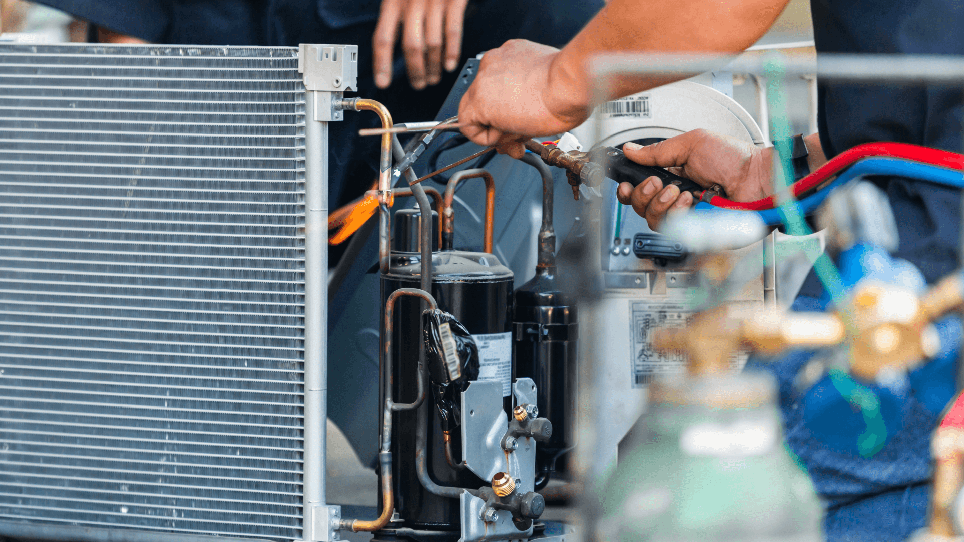 Close-up of an HVAC technician repairing air conditioning components, including copper piping and refrigerant lines.