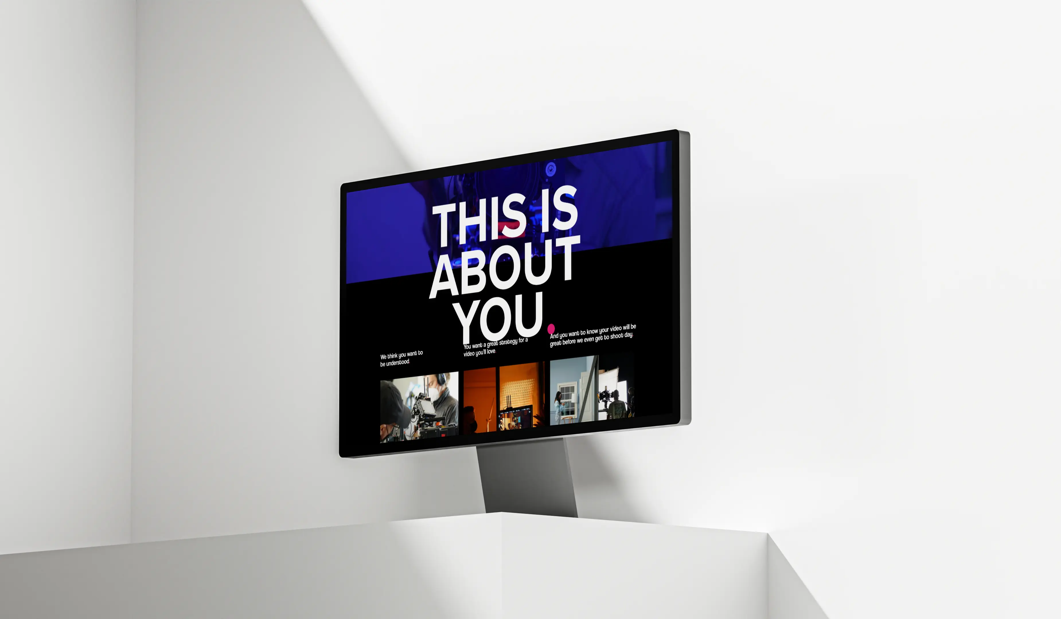 A modern display monitor mounted on a wall, showcasing a vibrant graphic with text and design elements.