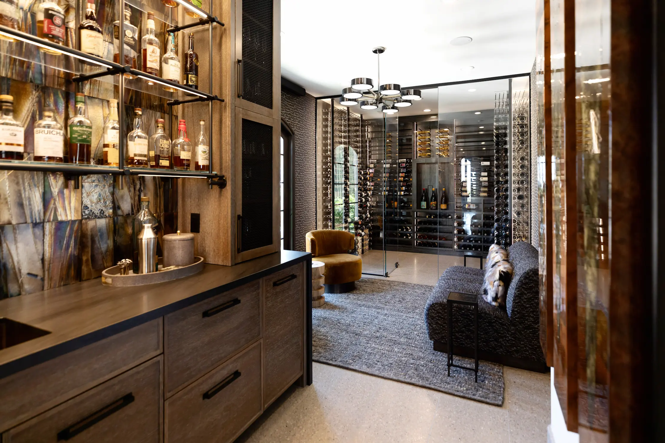 A sophisticated lounge terrace with curved white stucco walls, stone seating, and arched cutouts perfectly framing an unobstructed ocean sunset.