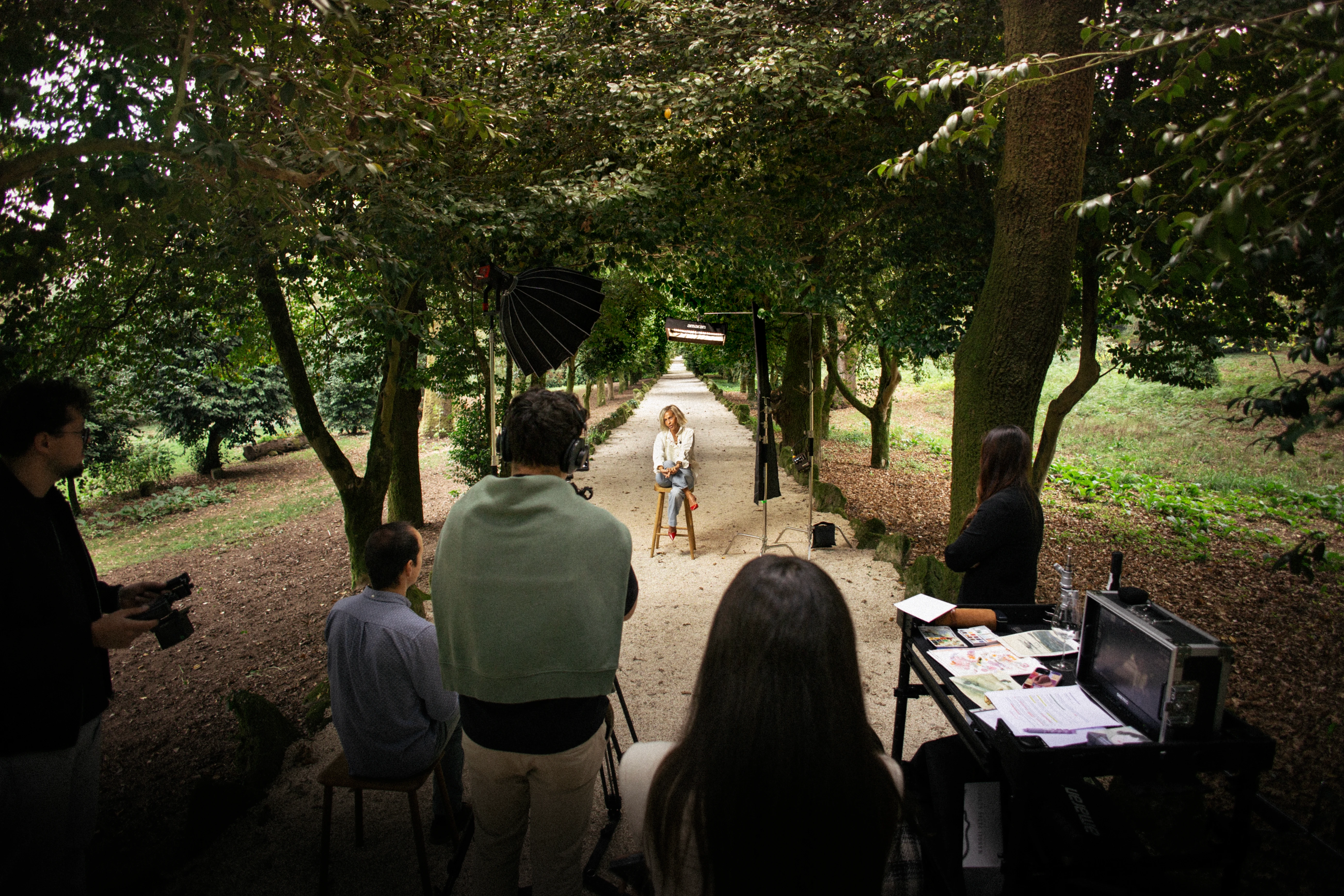 Smart speaker with a glowing top, placed on a circular base in a dark room.