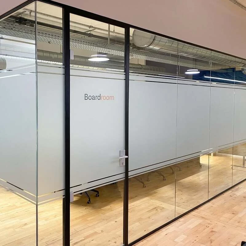 Glass boardroom walls with frosted vinyl and minimalist lettering 'boardroom'