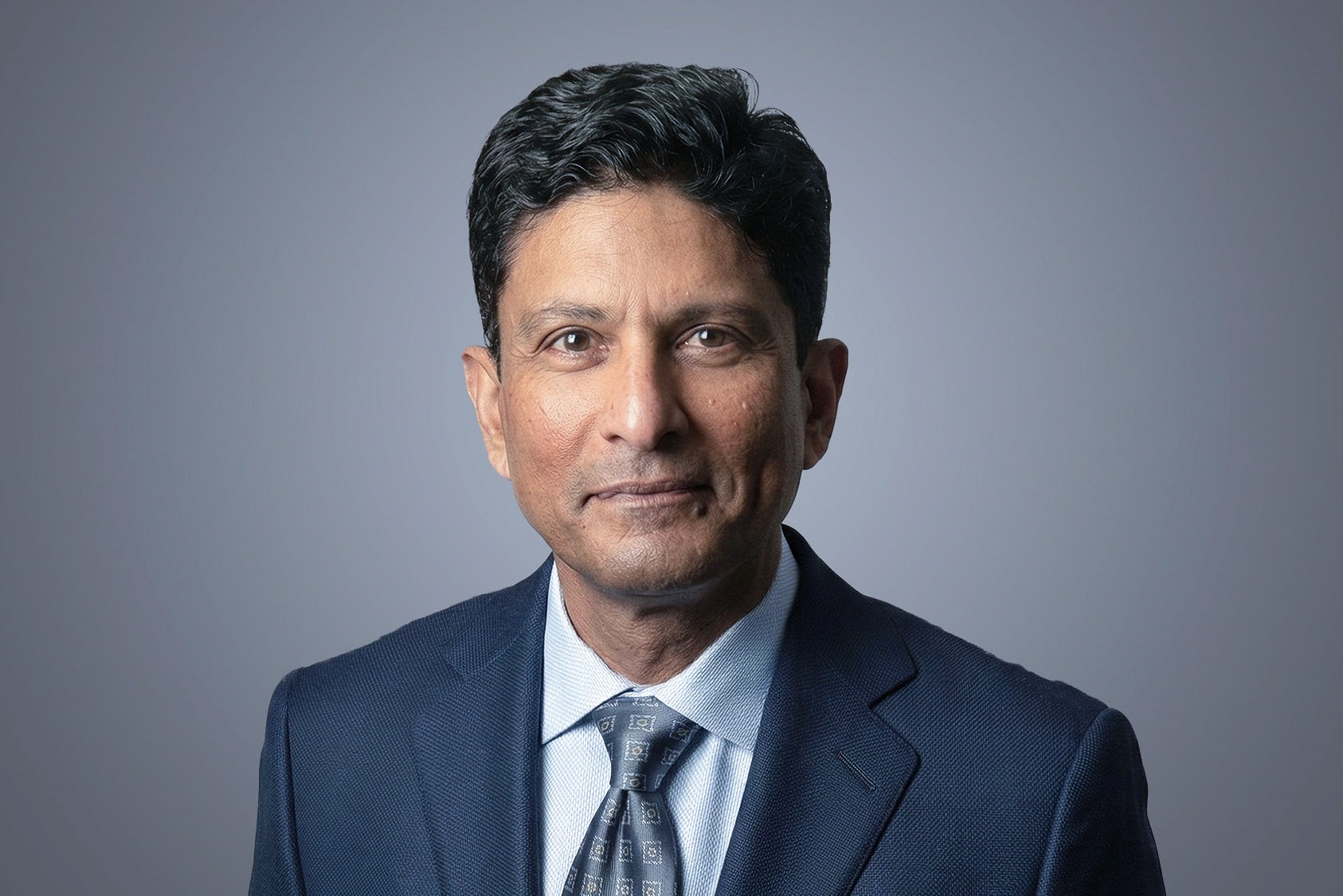 Edward Rajasingha, SteriMax Chief Commercial Officer: Smiling in professional business attire against a neutral studio background.