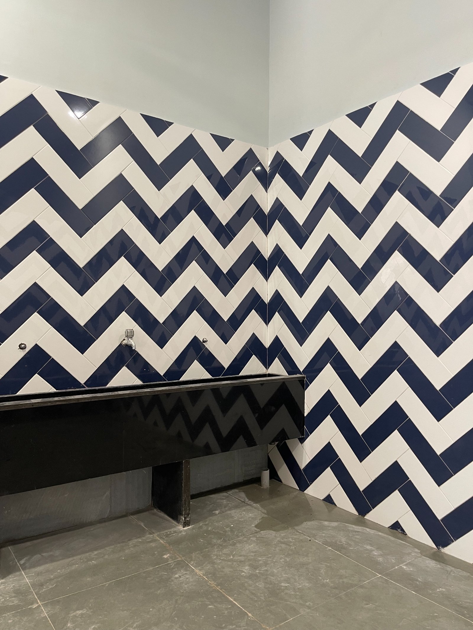 Nature-inspired preschool entrance with sculptural tree partitions and suspended green leaf ceiling panels.