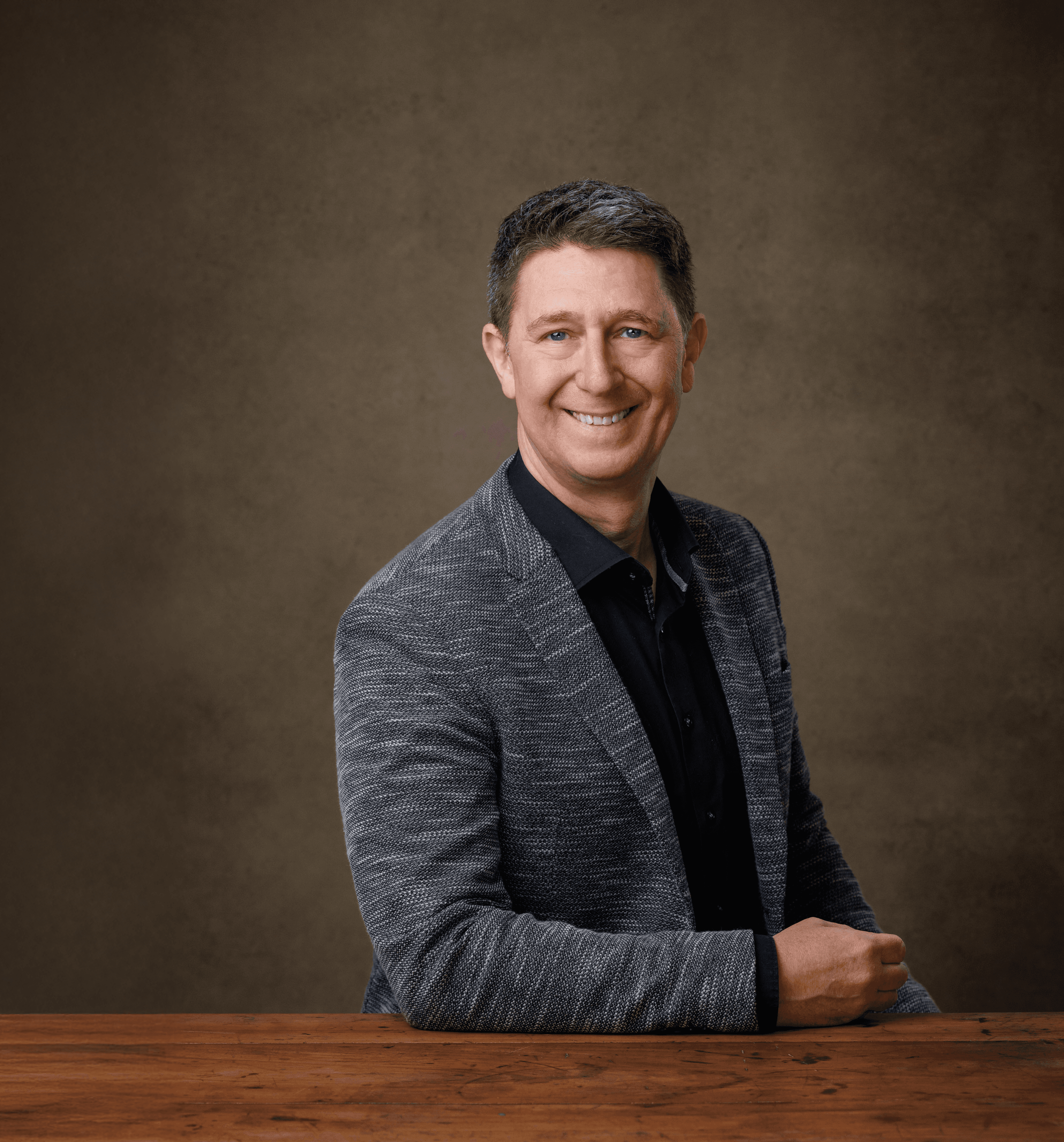 woman in blue tank top standing beside white wall