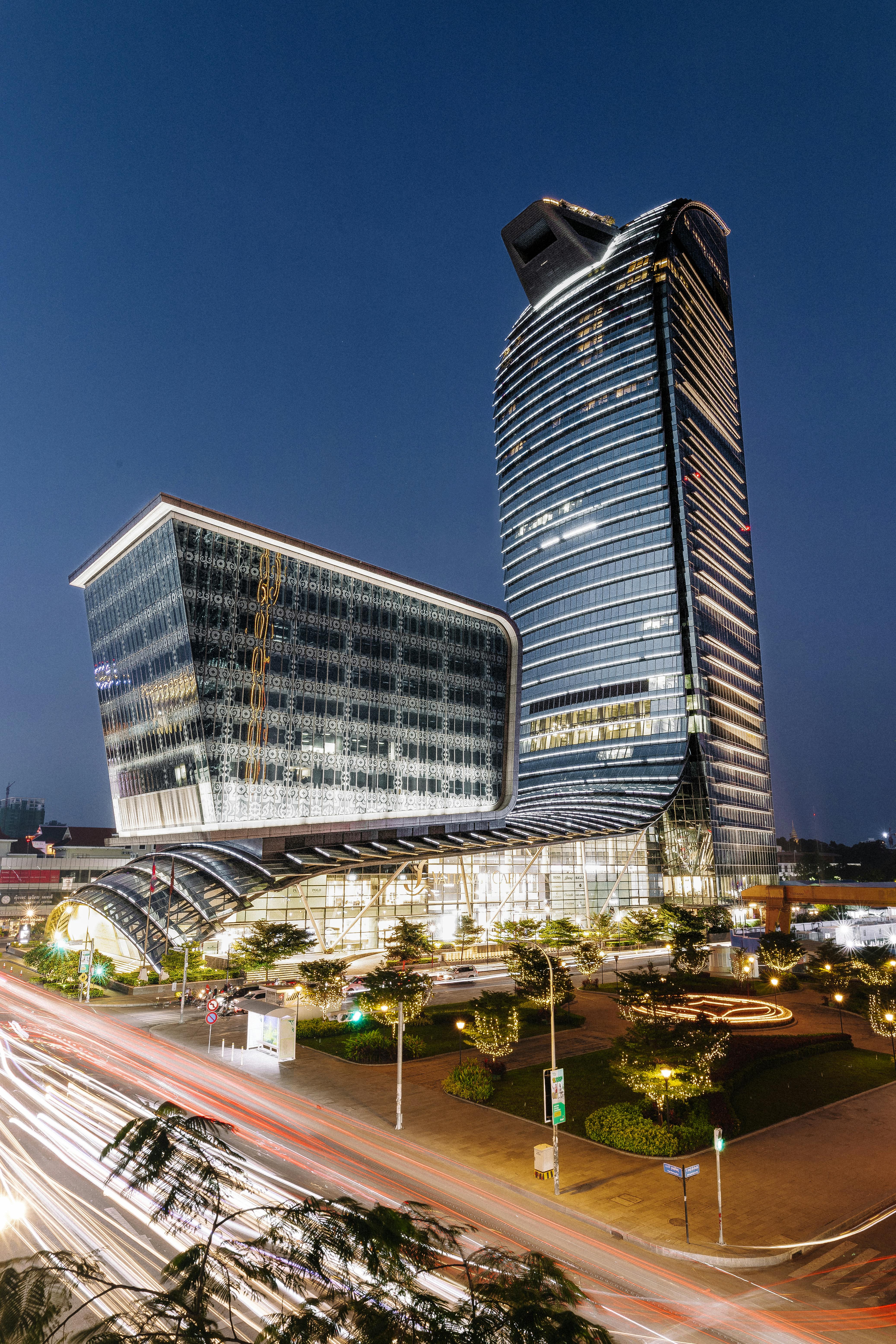 Night view of a podium-and-tower commercial building illustrating the urban typology that shapes street-level performance and mixed-use value