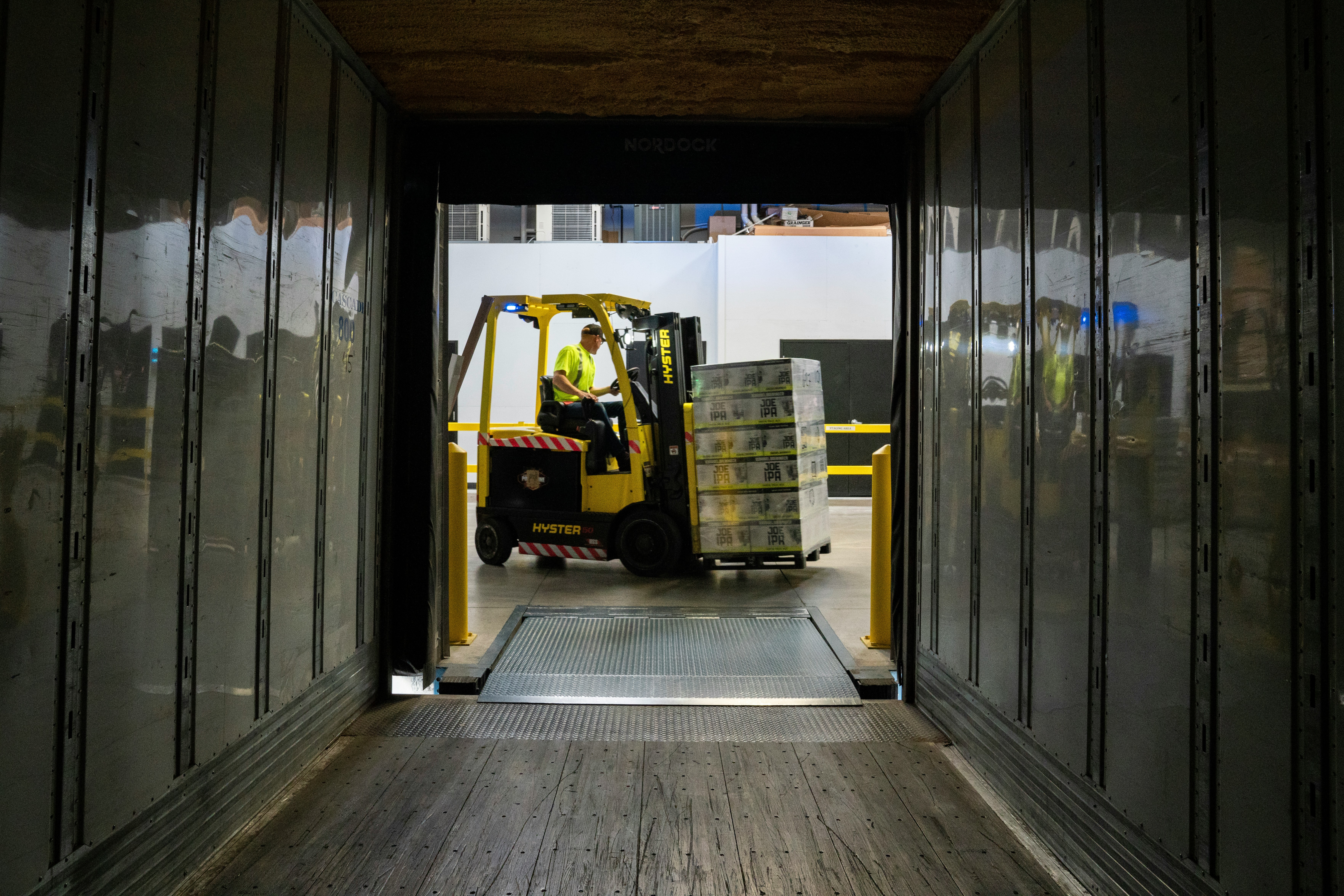 looking down a lorry trailer with a forklift unloading