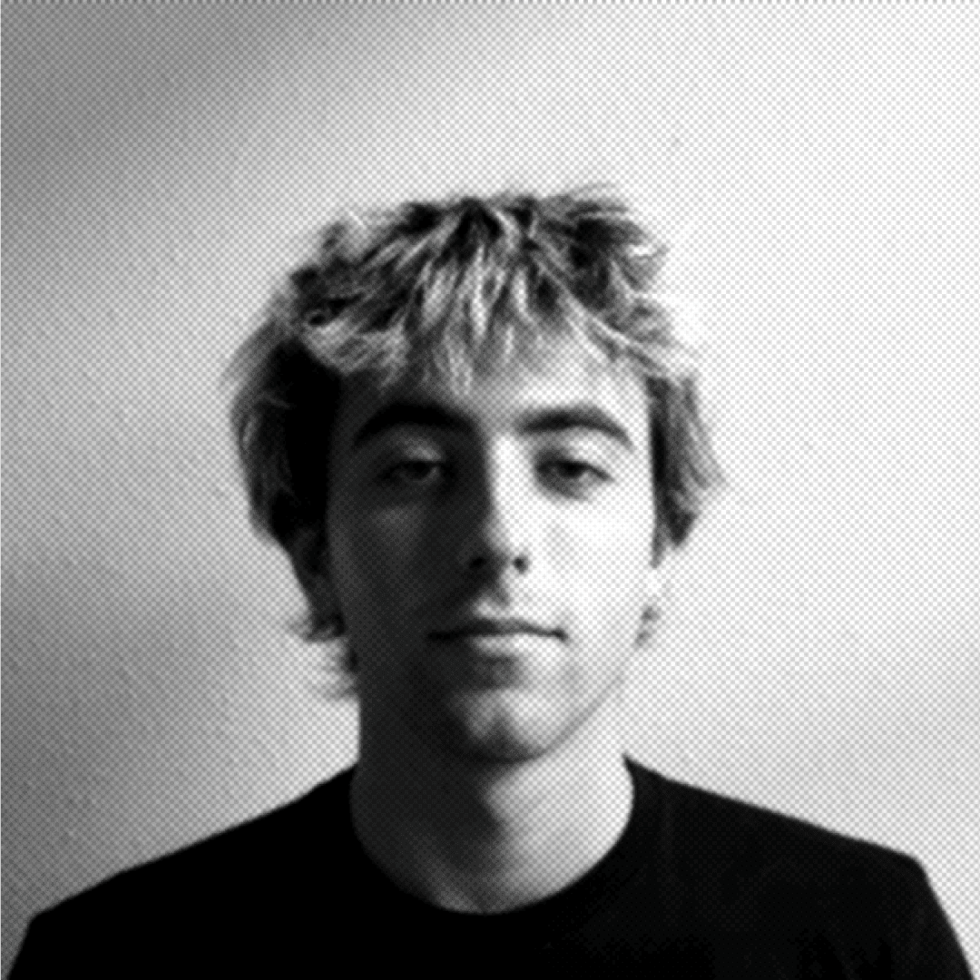 A thoughtful young person with dark hair gazes to the side, captured in soft black and white lighting.