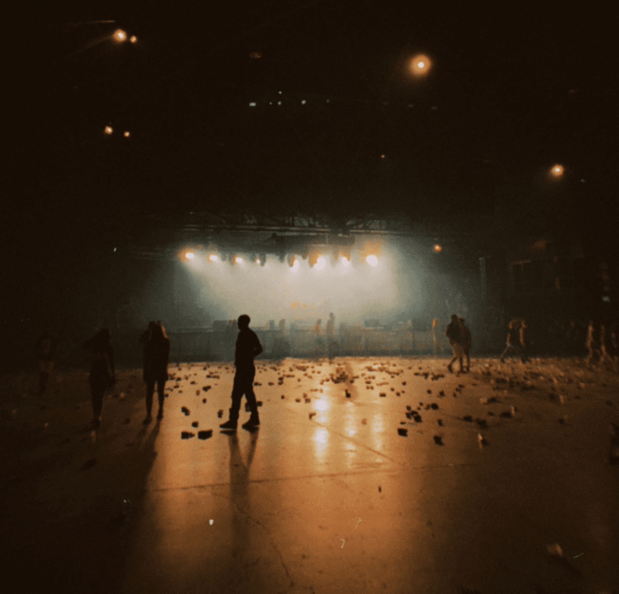Halvtom arena efter en konsert. Scenljus tänt och några enstaka personer står kvar.