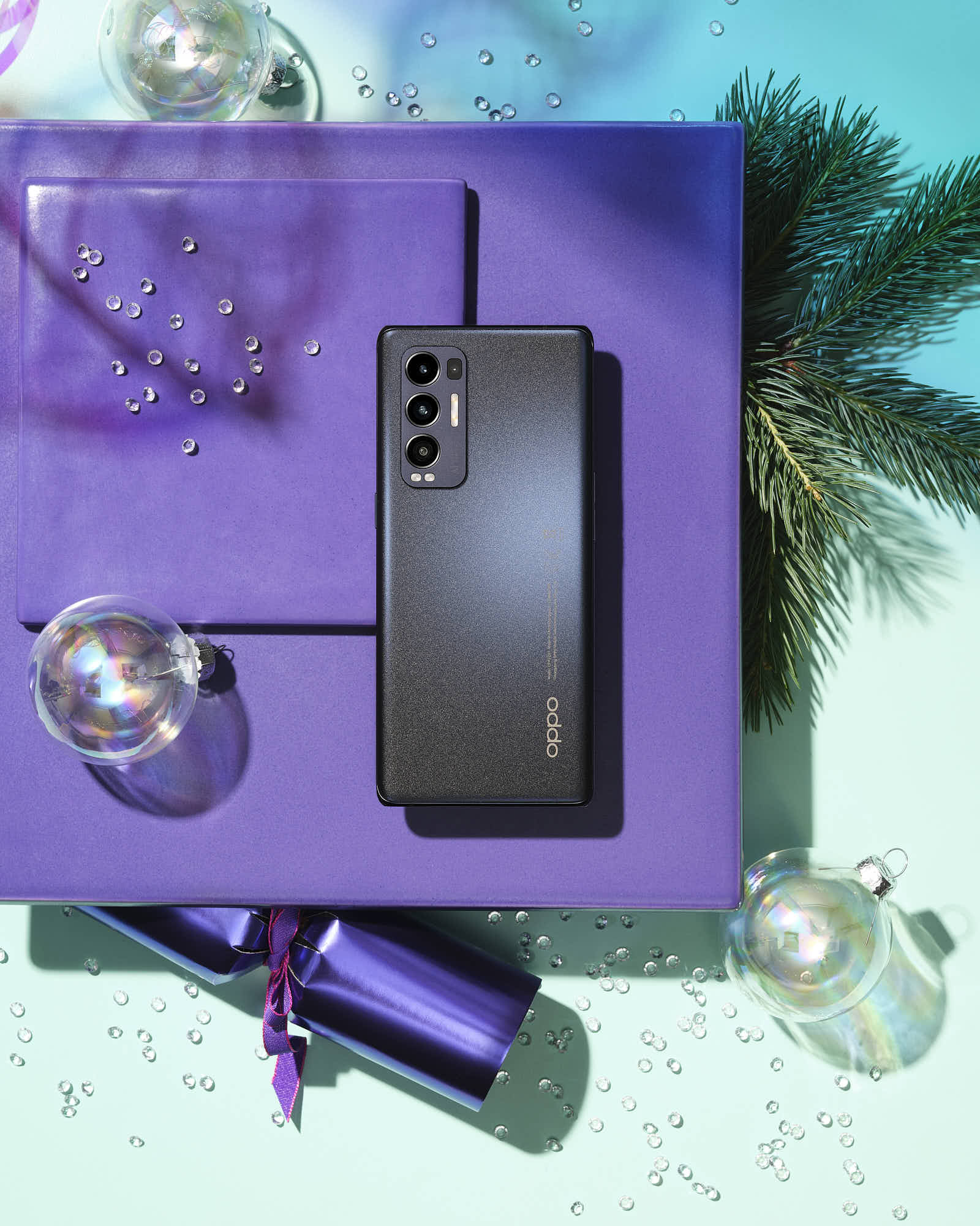A smartphone is placed on a textured purple background with decorative items like seashells and vibrant accessories.