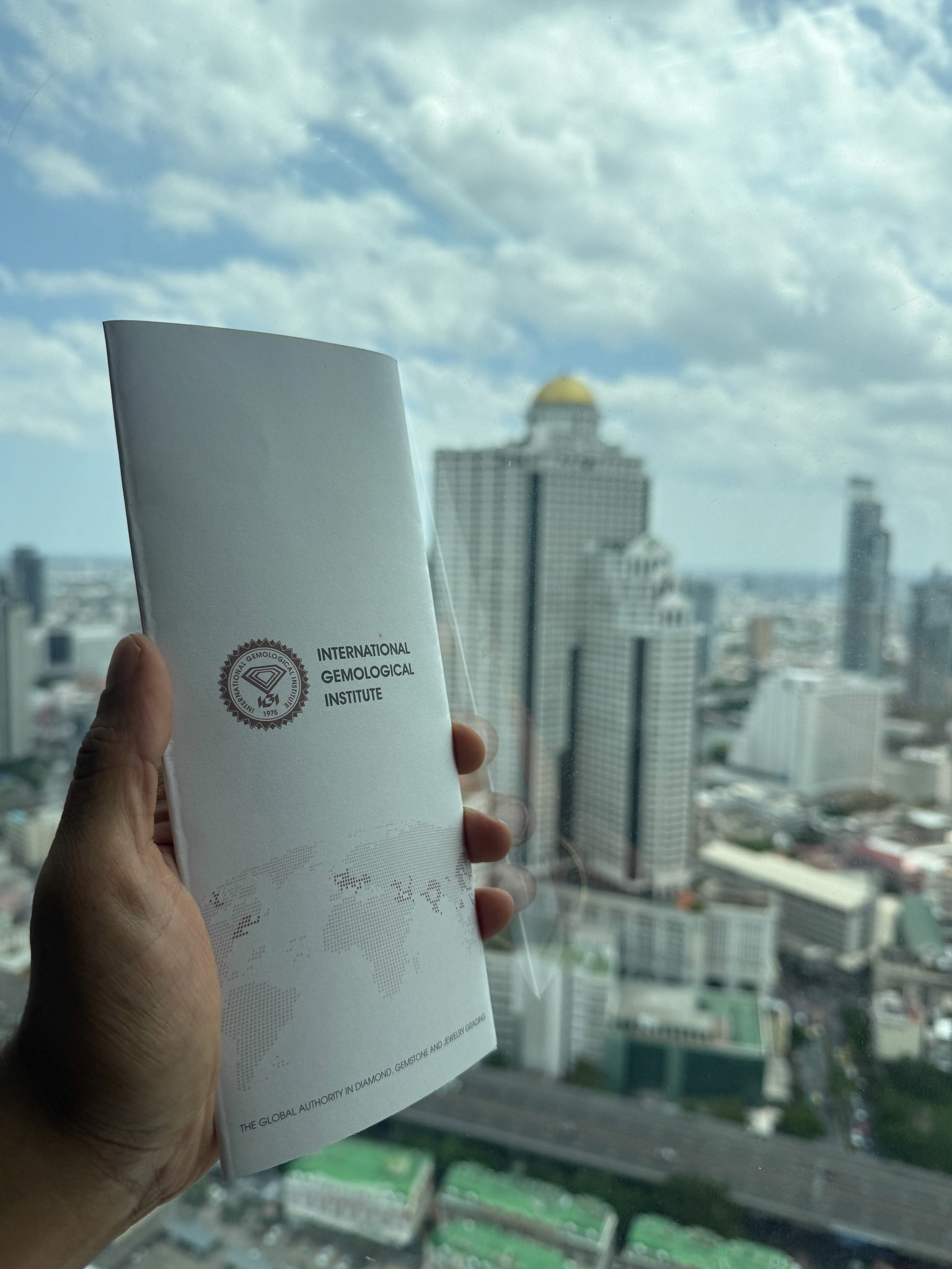 IGI-certified lab grown diamond certificate next to State Tower from Lab Grown Dreams office.