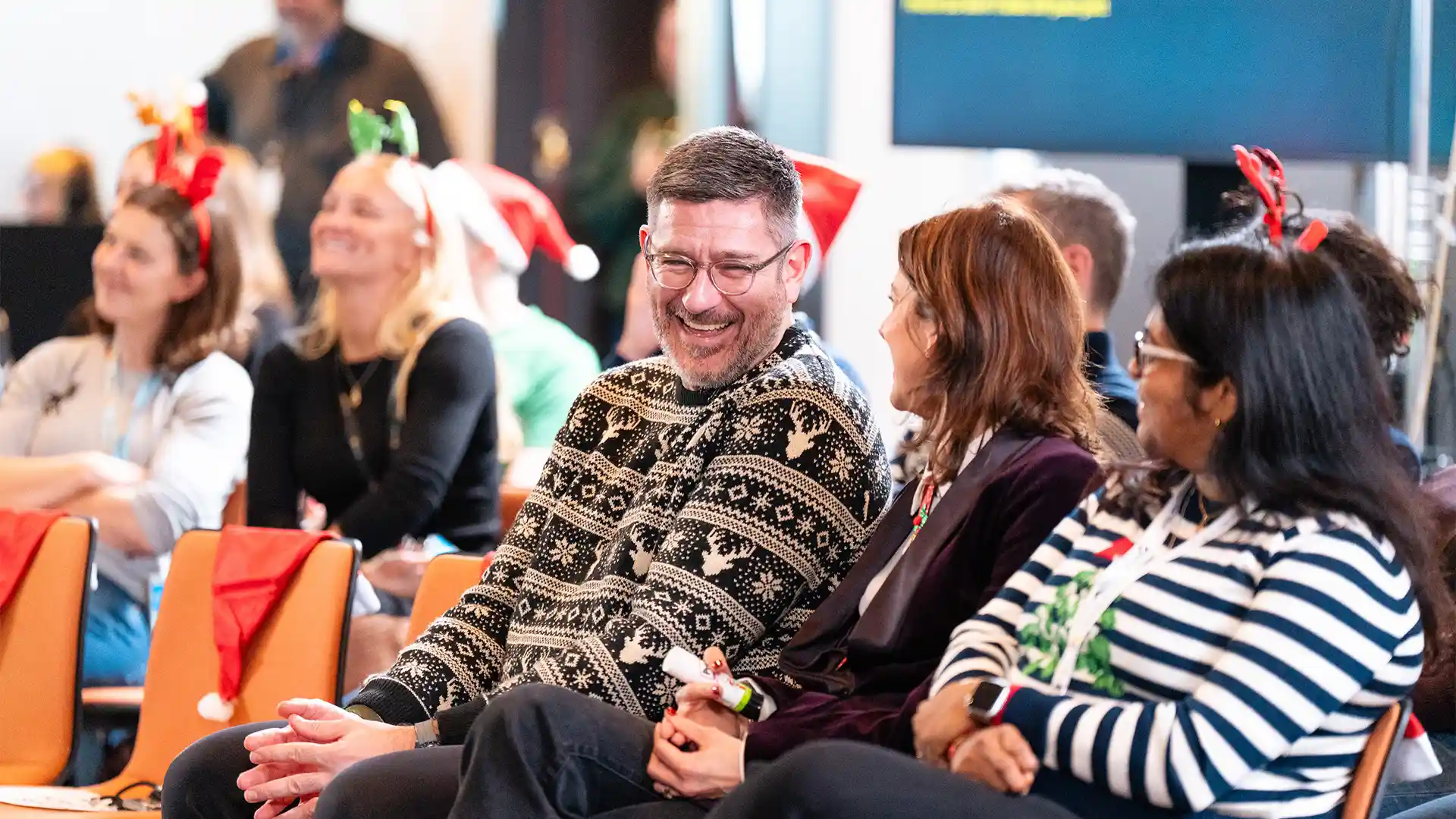 Audience members sharing a relaxed moment during a live corporate event, highlighting engagement and informal connection.