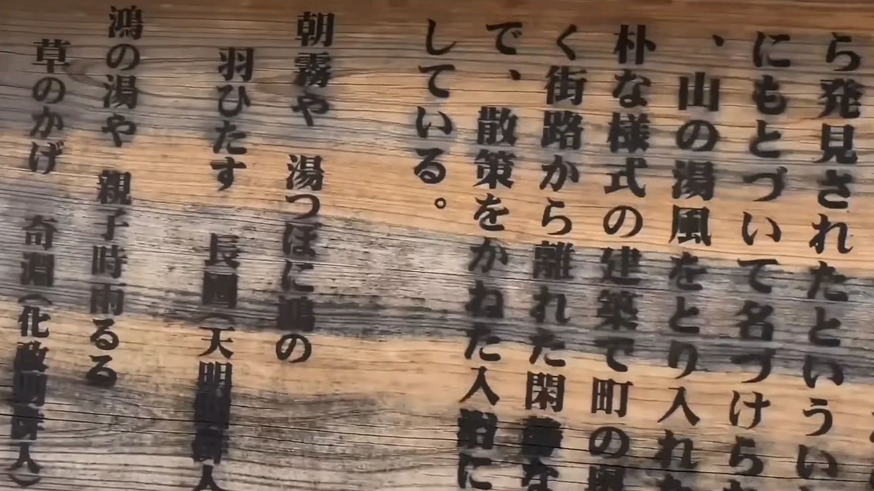 Interpretive board beside a Kinosaki bathhouse describing the stork legend of Ko-no-yu in Japanese.