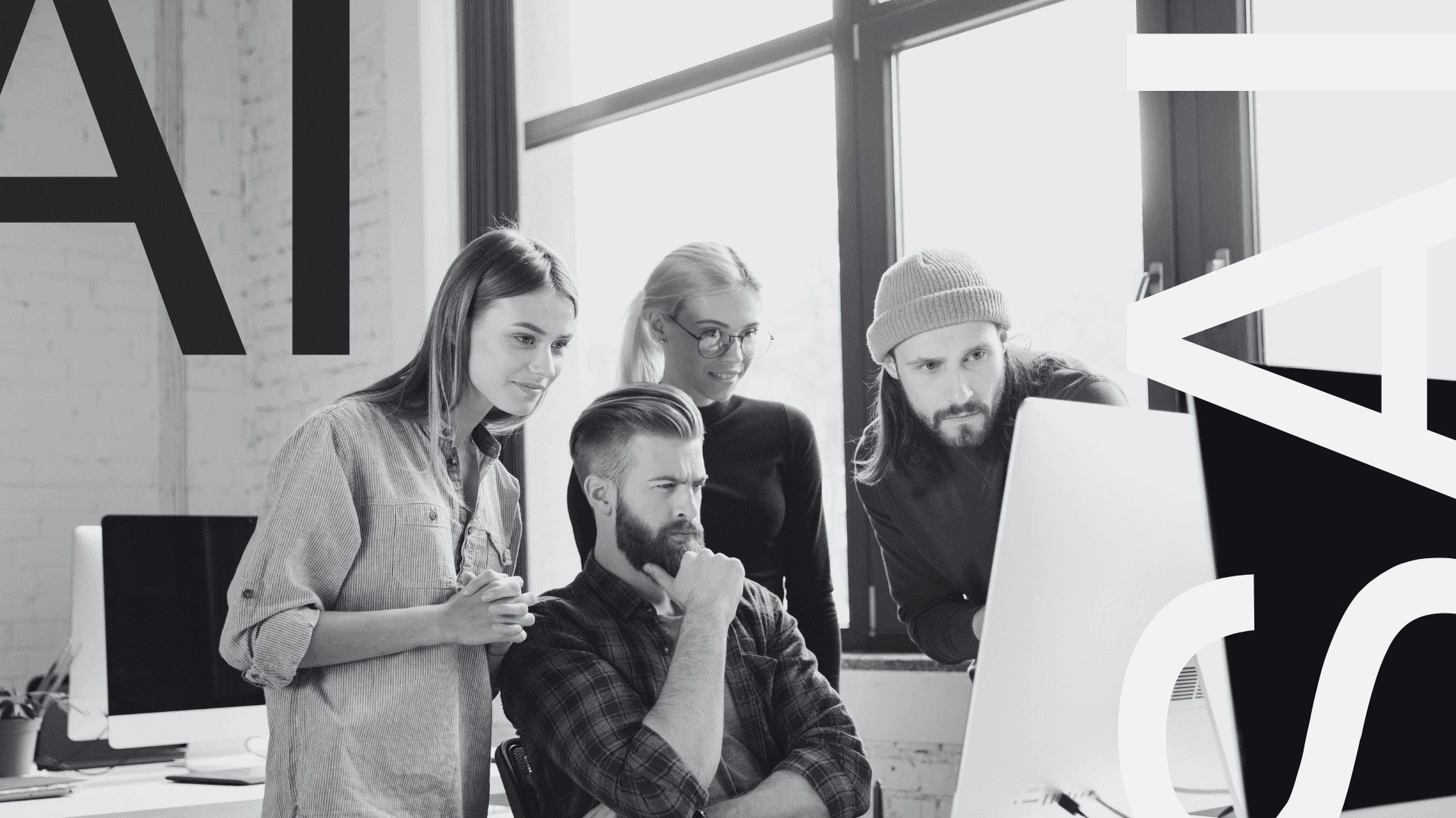 A team of 4 people, looking at a computer screen 