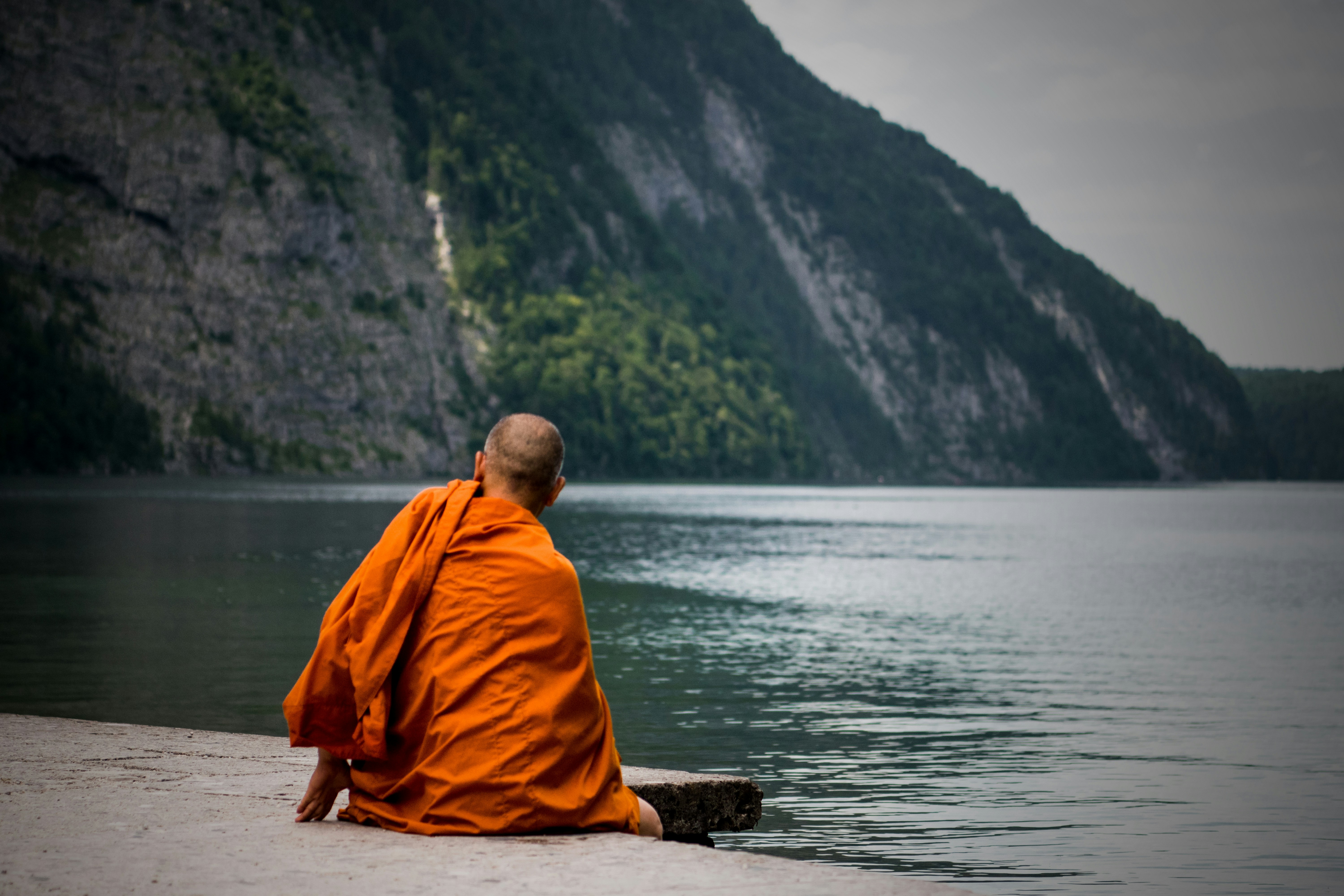 A monk meditating by the river is in a spiritual flow state