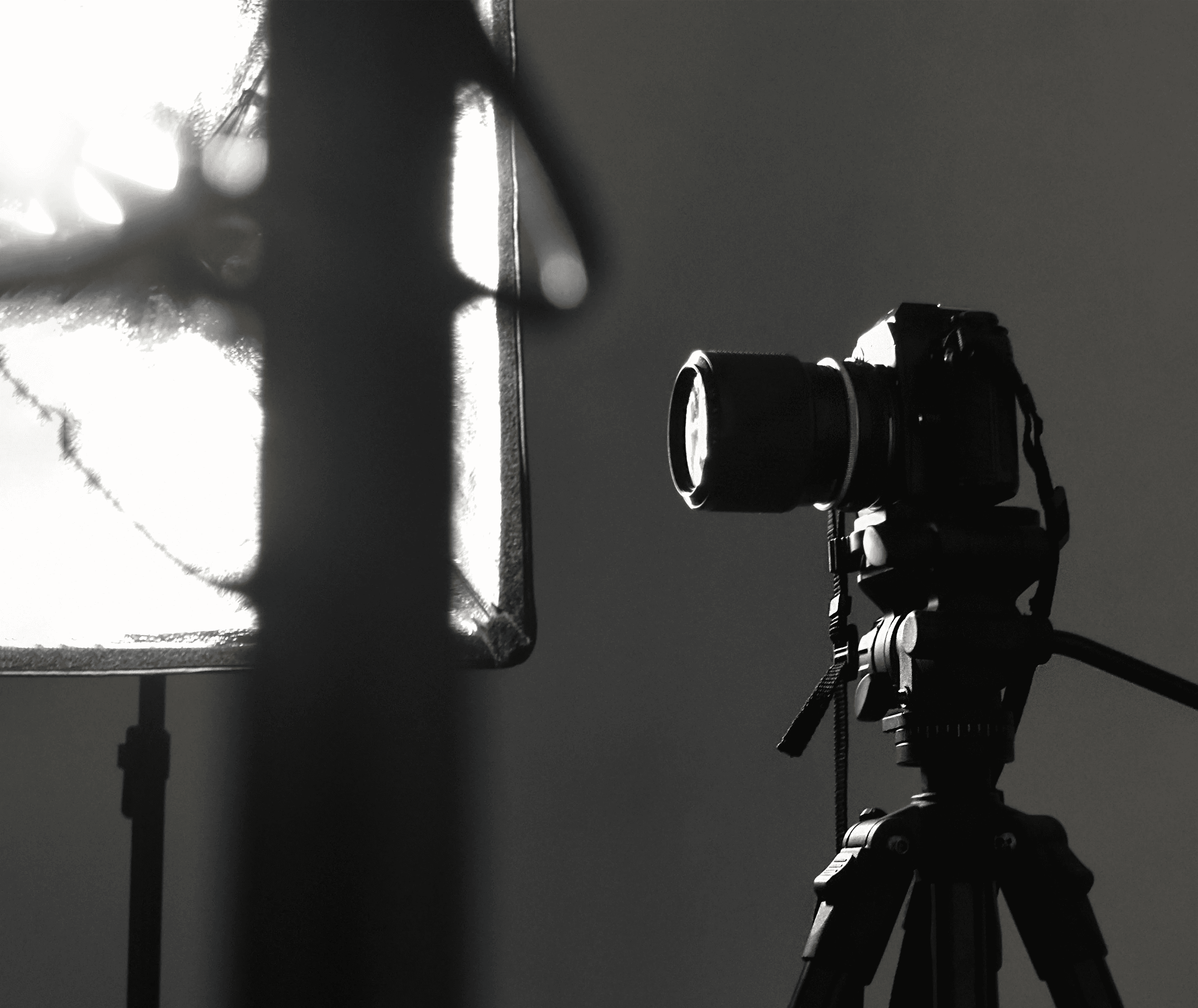 black camera on tripod in grayscale photography