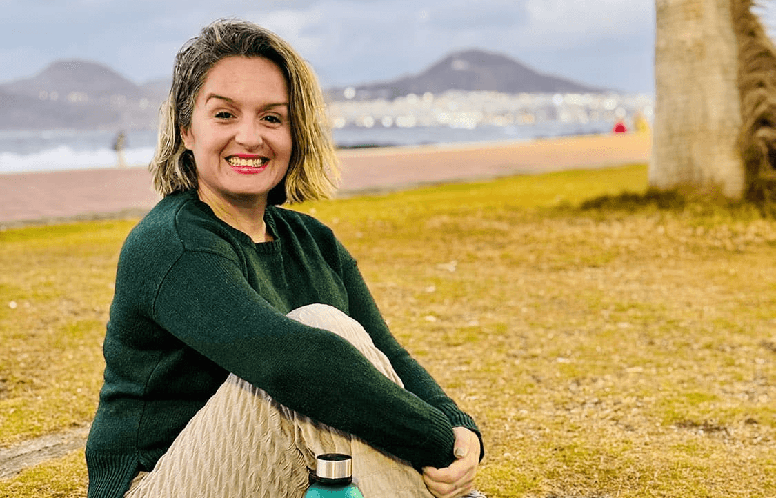 Freckled woman with brown hair and eyes.