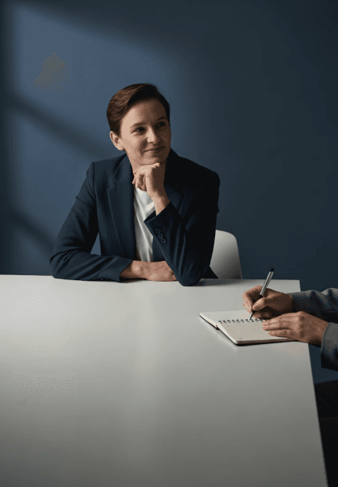 Close-up of a dark green leaf showing its textured surface and central vein against a muted background.