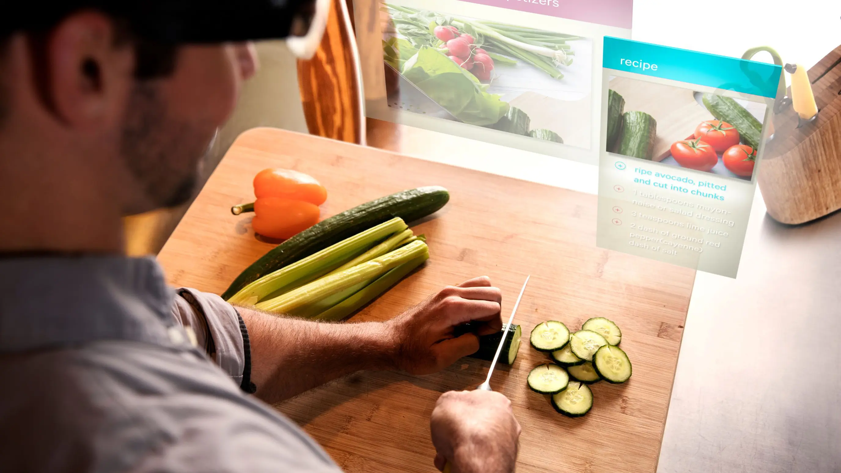 A man chops vegetables at a kitchen counter while AR overlays display a floating recipe card with ingredient steps and food imagery, demonstrating hands-free cooking assistance through smart glasses.