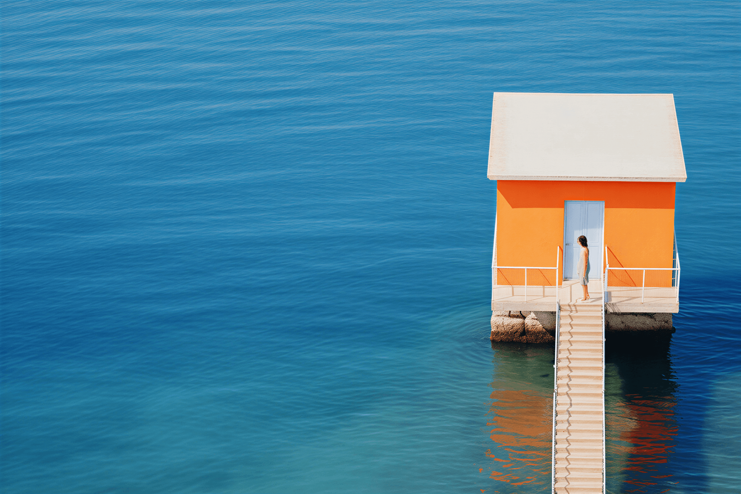 Orange room with windows looking out to the ocean.