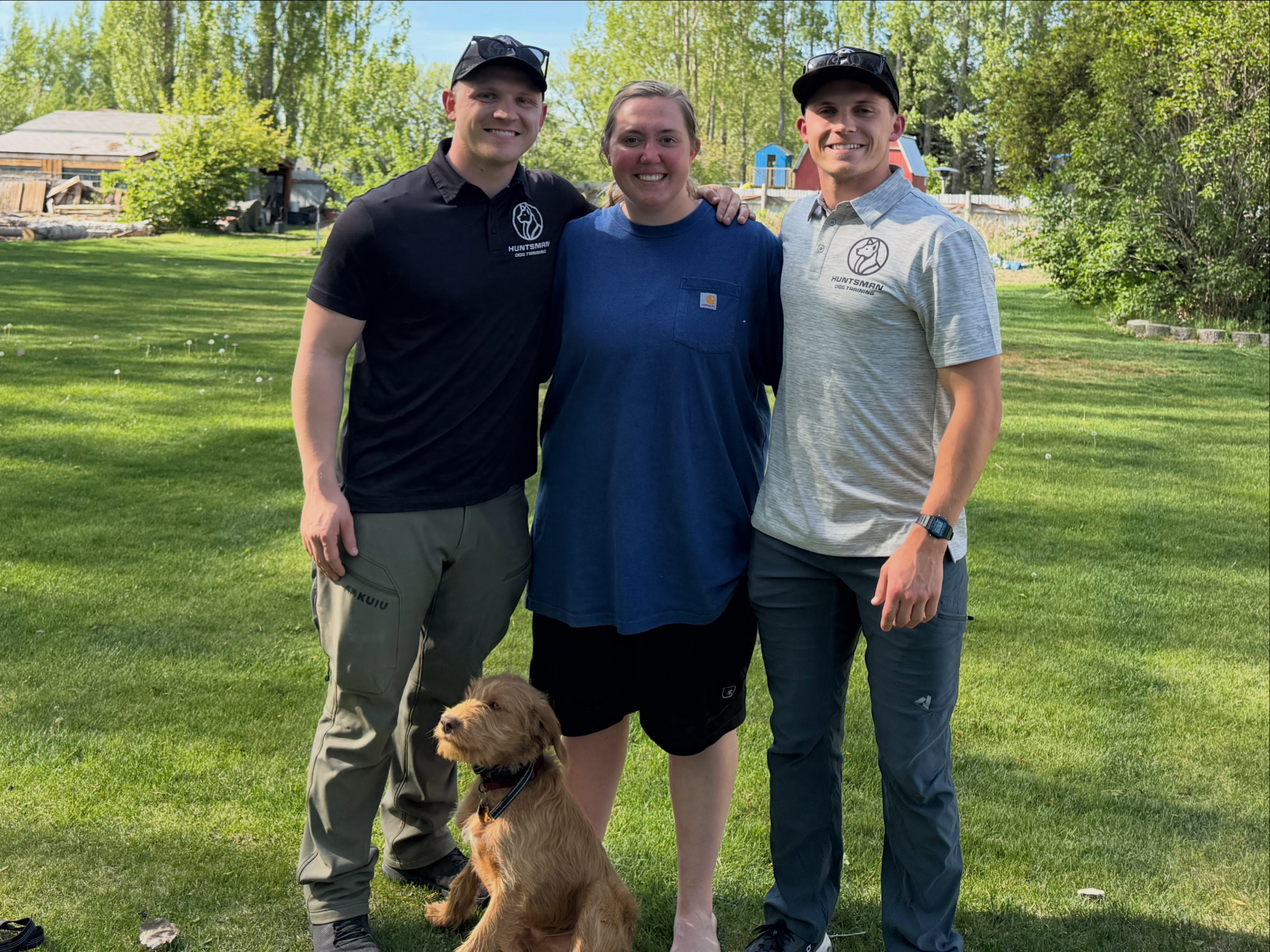 Two Huntsman Dog Training Trainers Standing with their client and her dog