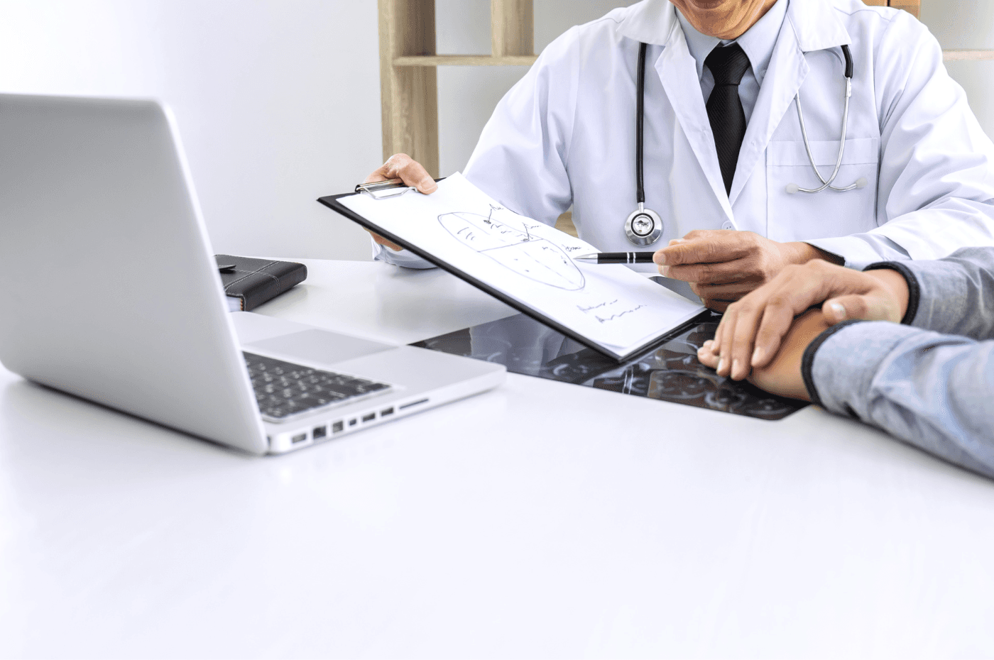 Doctor Showing Chart To Patient At Clinic