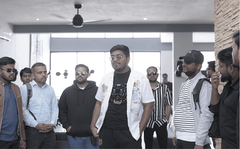 Two men discuss a project while standing at a laptop in an office.