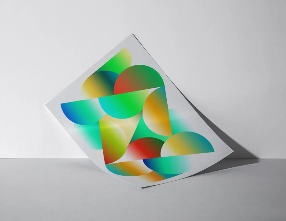 Poster mockup featuring a vibrant abstract design with overlapping colorful gradients and geometric shapes. The poster leans against a white wall on a gray surface, with soft shadows enhancing the composition.
