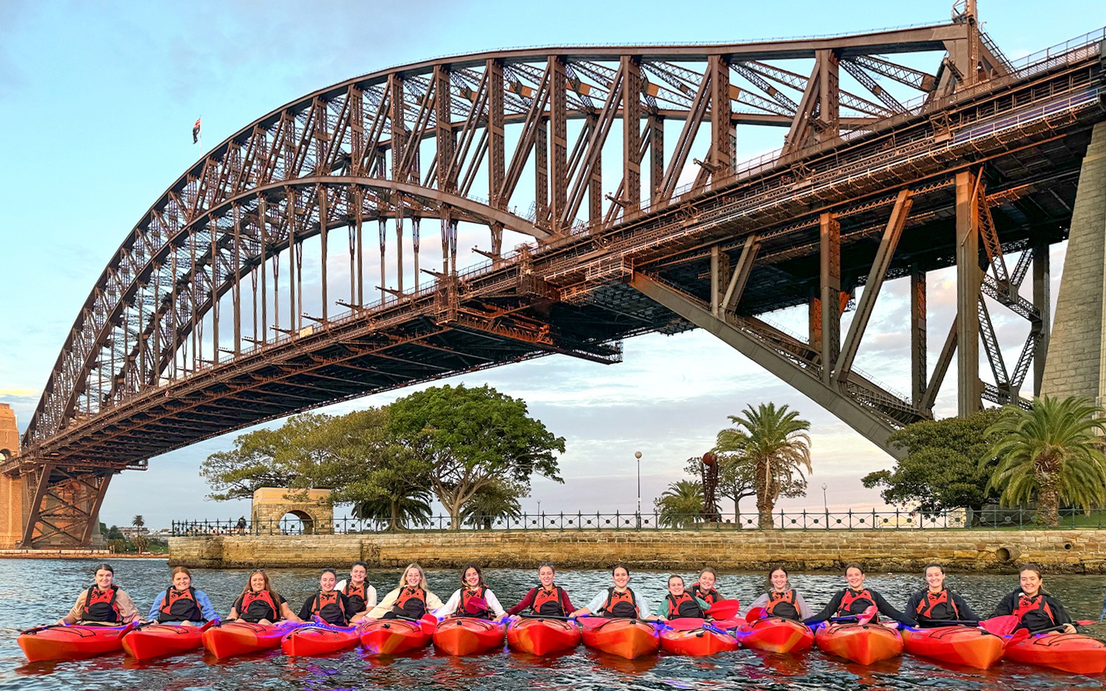 Group of people enjoying a sunrise paddle on Sydney Harbour with a breakfast picnic, with the iconic Sydney Opera House in the background